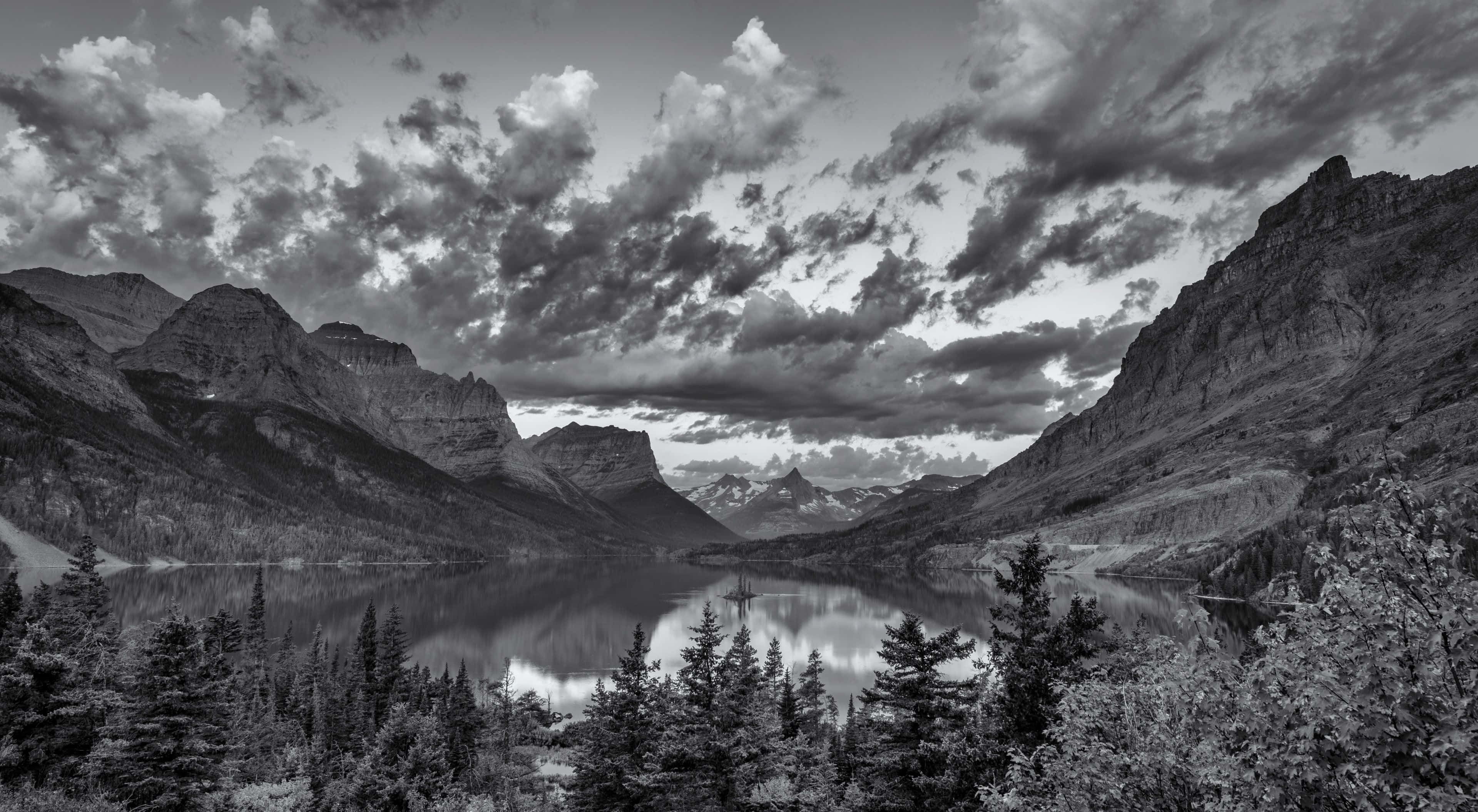 Black And White Landscape 桌布 壁紙 — 一個戲劇性的黑白山谷，平靜的湖泊映照著高聳的山峰和紋理豐富的雲層。