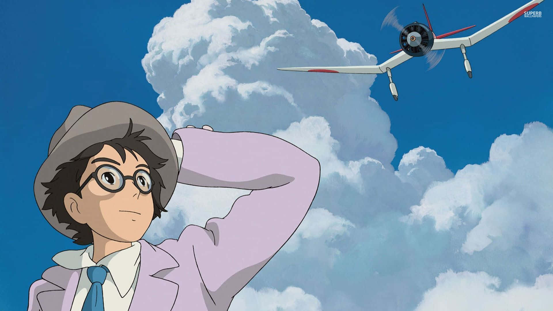 The Wind Rises 桌布 壁紙 — 一個戴帽子和眼鏡的小男孩抬頭仰望，一架白色滑翔機在佈滿蓬鬆白雲的明亮藍天中翱翔。