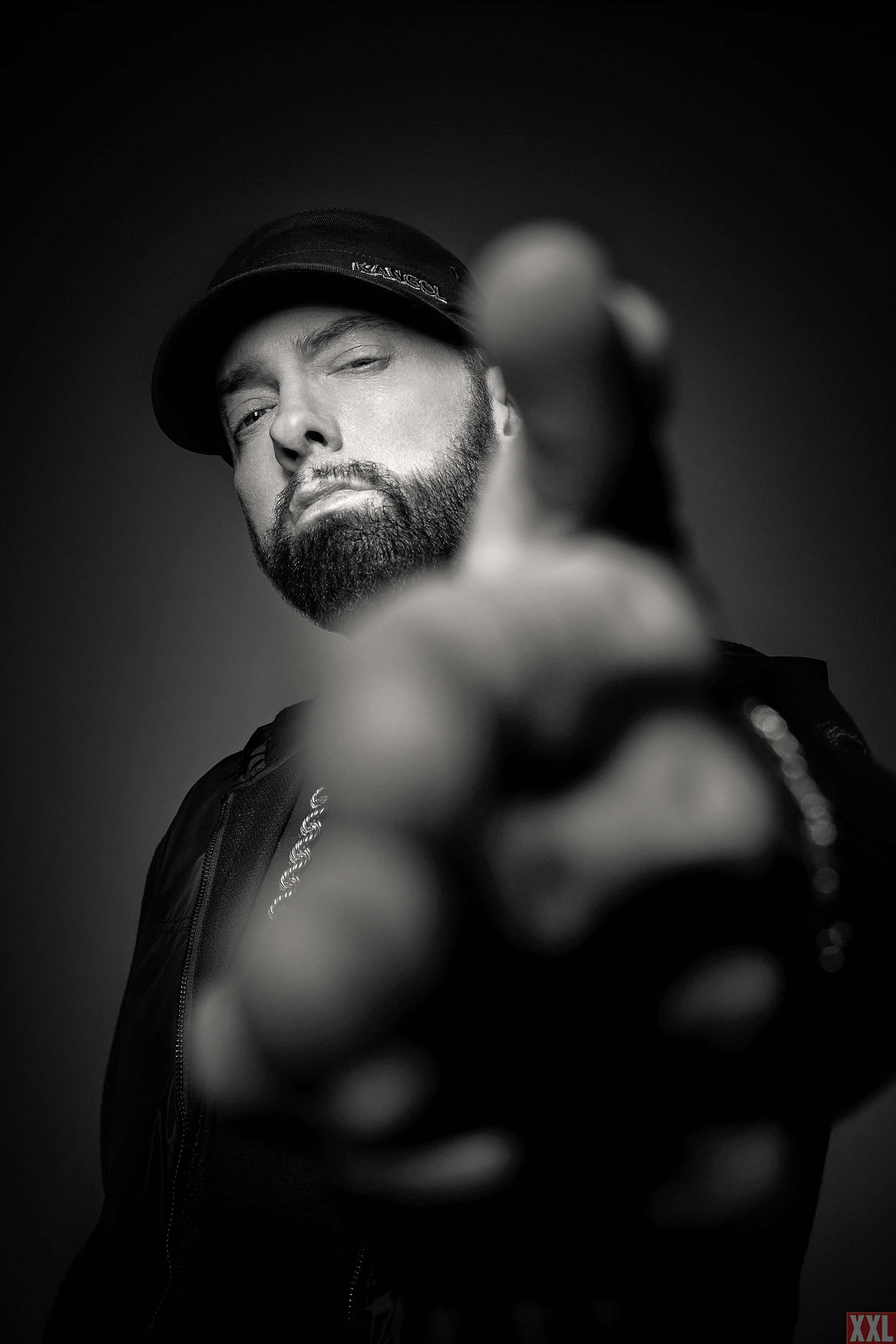 Eminem 桌布 壁紙 — 一個戴帽留鬚的男人，表情嚴肅，直接指向觀看者的黑白肖像。