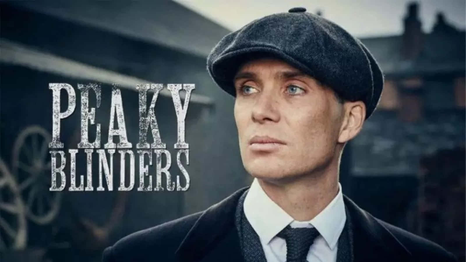 Peaky Blinders 桌布 壁紙 — 一個戴平頂帽、穿西裝的男人，在粗糙的城市背景下，帶有「Peaky Blinders」文字，凝視著。