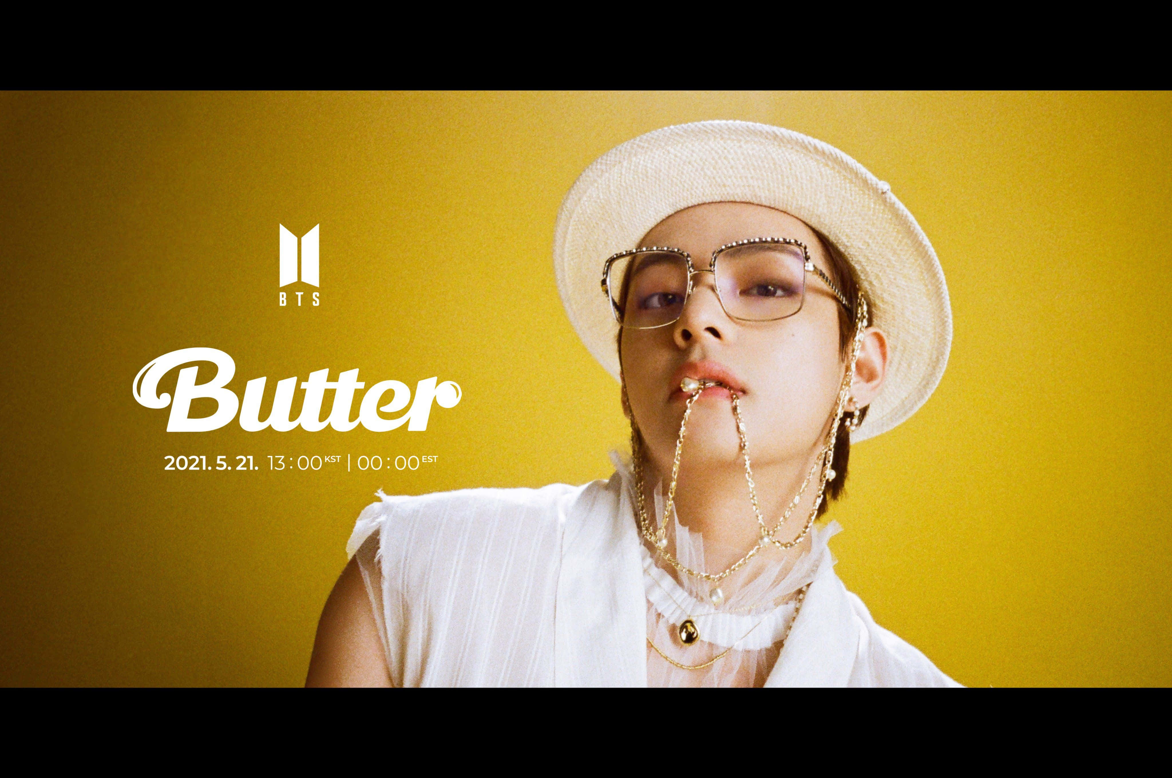 Bts Butter 桌布 壁紙 — 一個戴白色帽子和眼鏡的人，在充滿活力的黃色背景前擺姿勢，背景上有「Butter」文字。