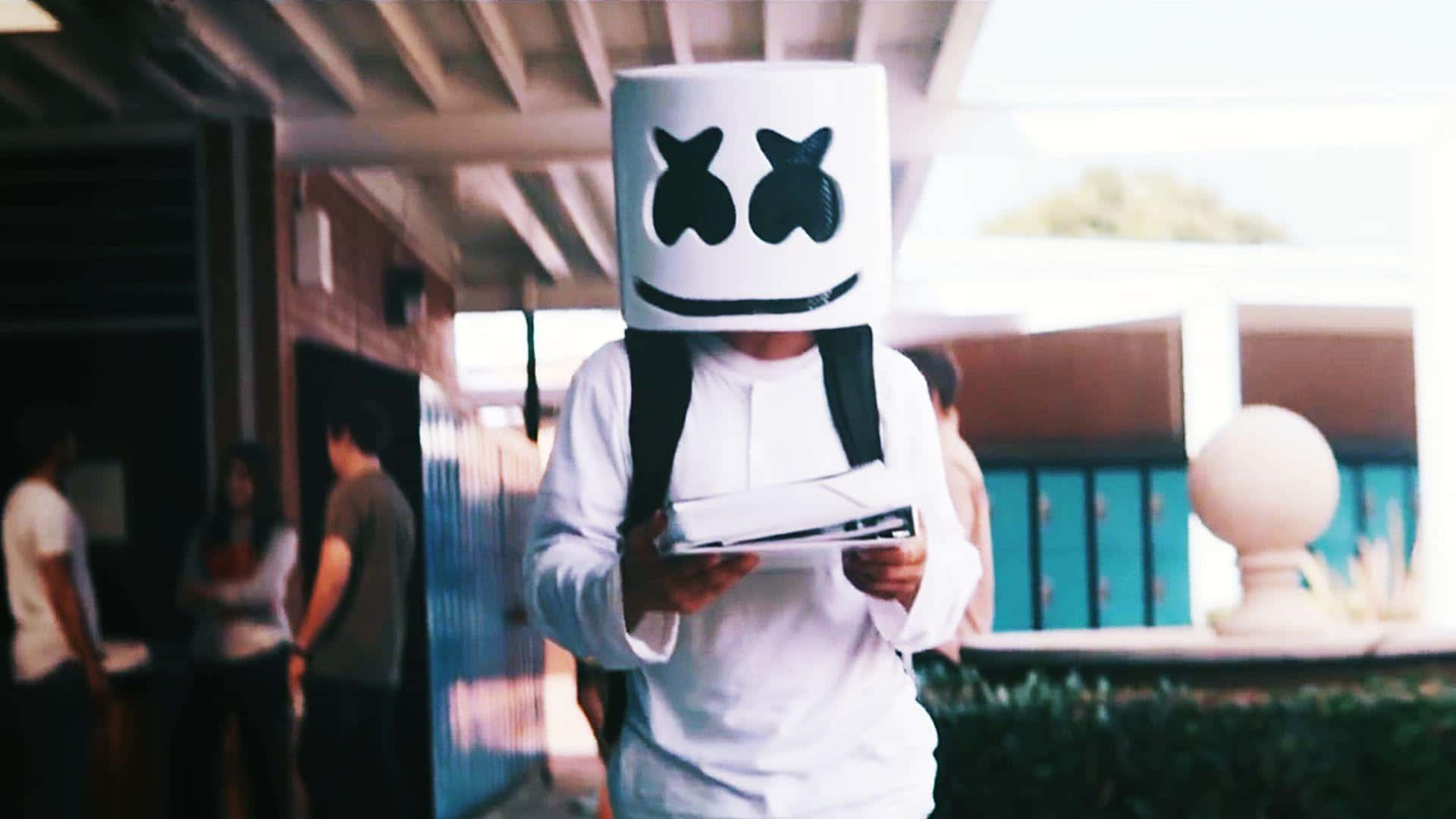 Marshmello 桌布 壁紙 — 一個戴着白色棉花糖頭盔、有黑色眼睛和笑容的人，在有蓋通道下拿着平板電腦。