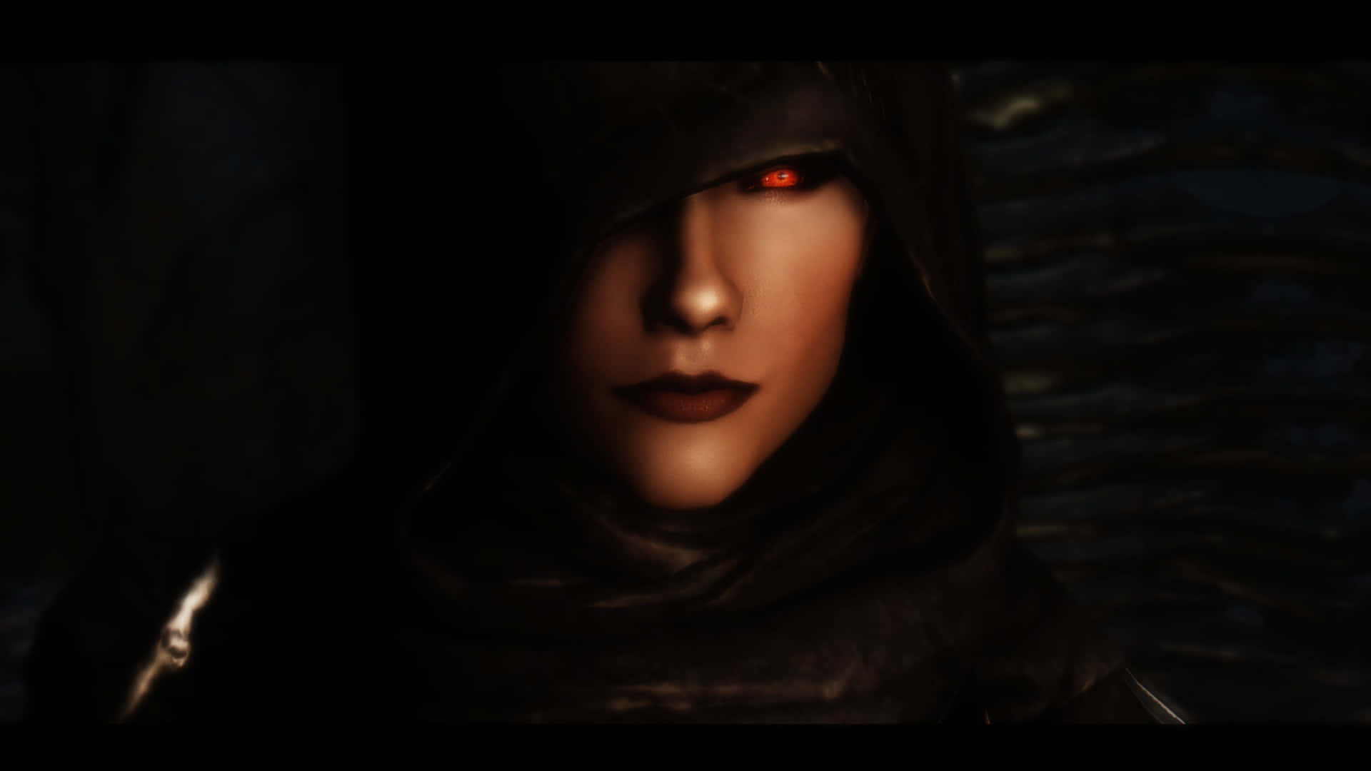 Skyrim Serana 桌布 壁紙 — 一個戴著兜帽、眼睛發出紅光的人物在黑暗陰影環境中凝視。