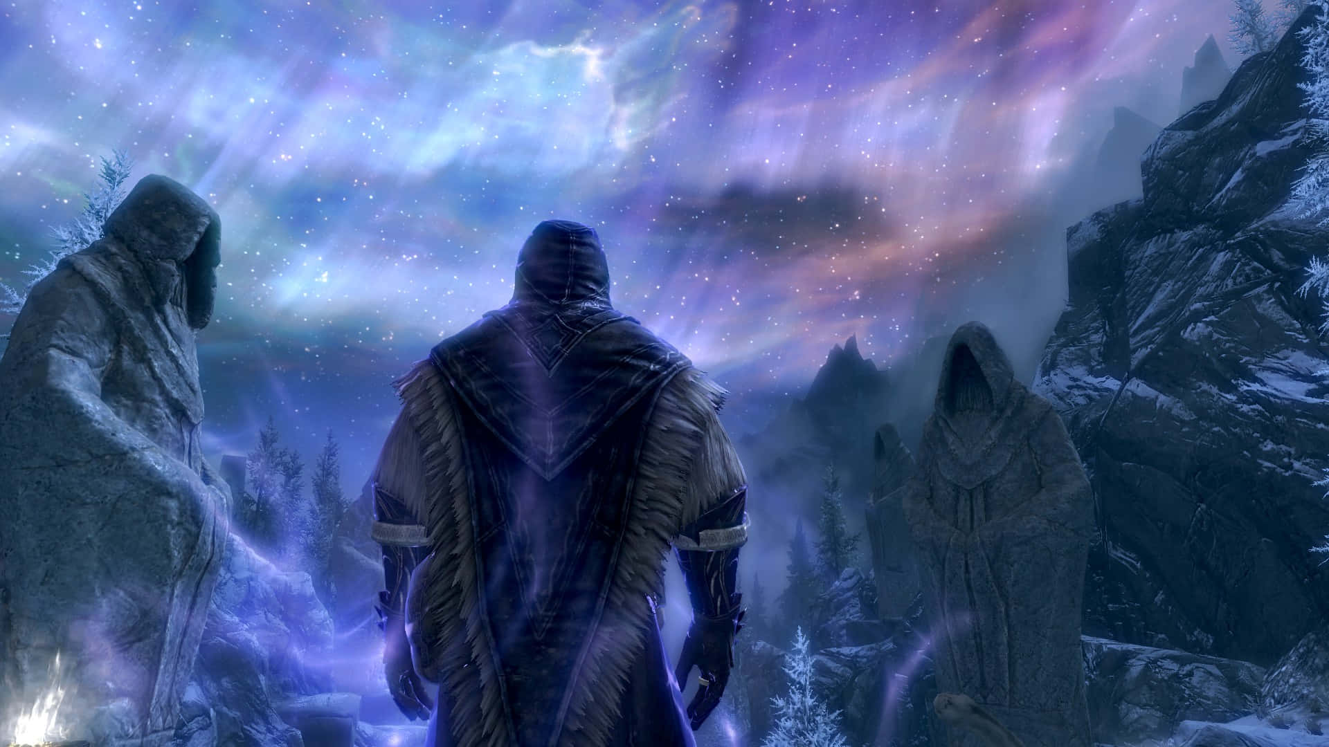 Sovngarde 桌布 壁紙 — 一個戴著兜帽的身影站在兩個石像之間，背景是雪覆蓋的山地景觀，夜空充滿了生動的極光。