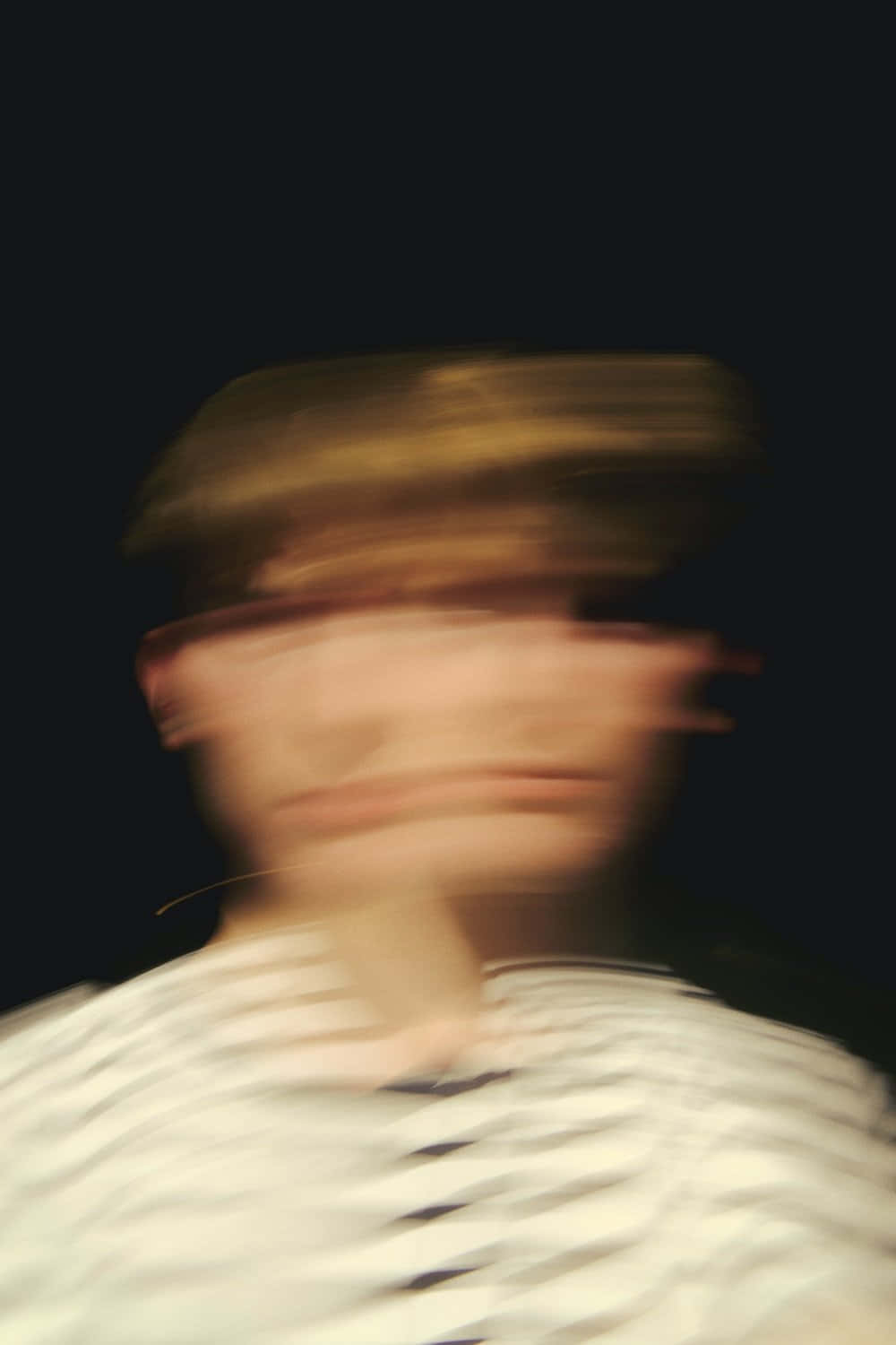 Motion Blur 桌布 壁紙 — 一個戴著帽子和條紋襯衫的人，在黑暗背景下的模糊動態肖像。