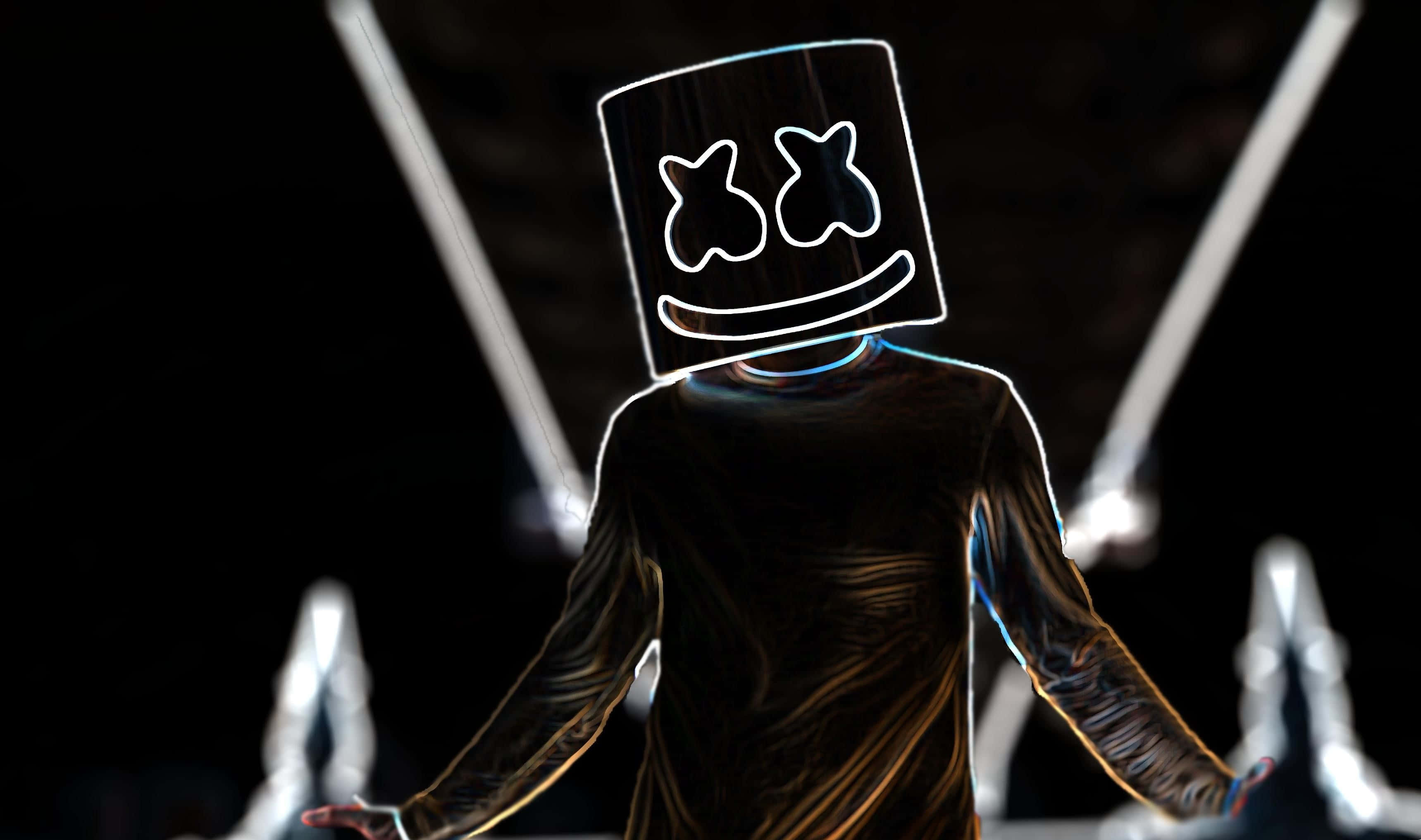Marshmello 桌布 壁紙 — 一個戴著發光棉花糖面具的人物在黑暗背景下站在舞台中央，被明亮的聚光燈照射。