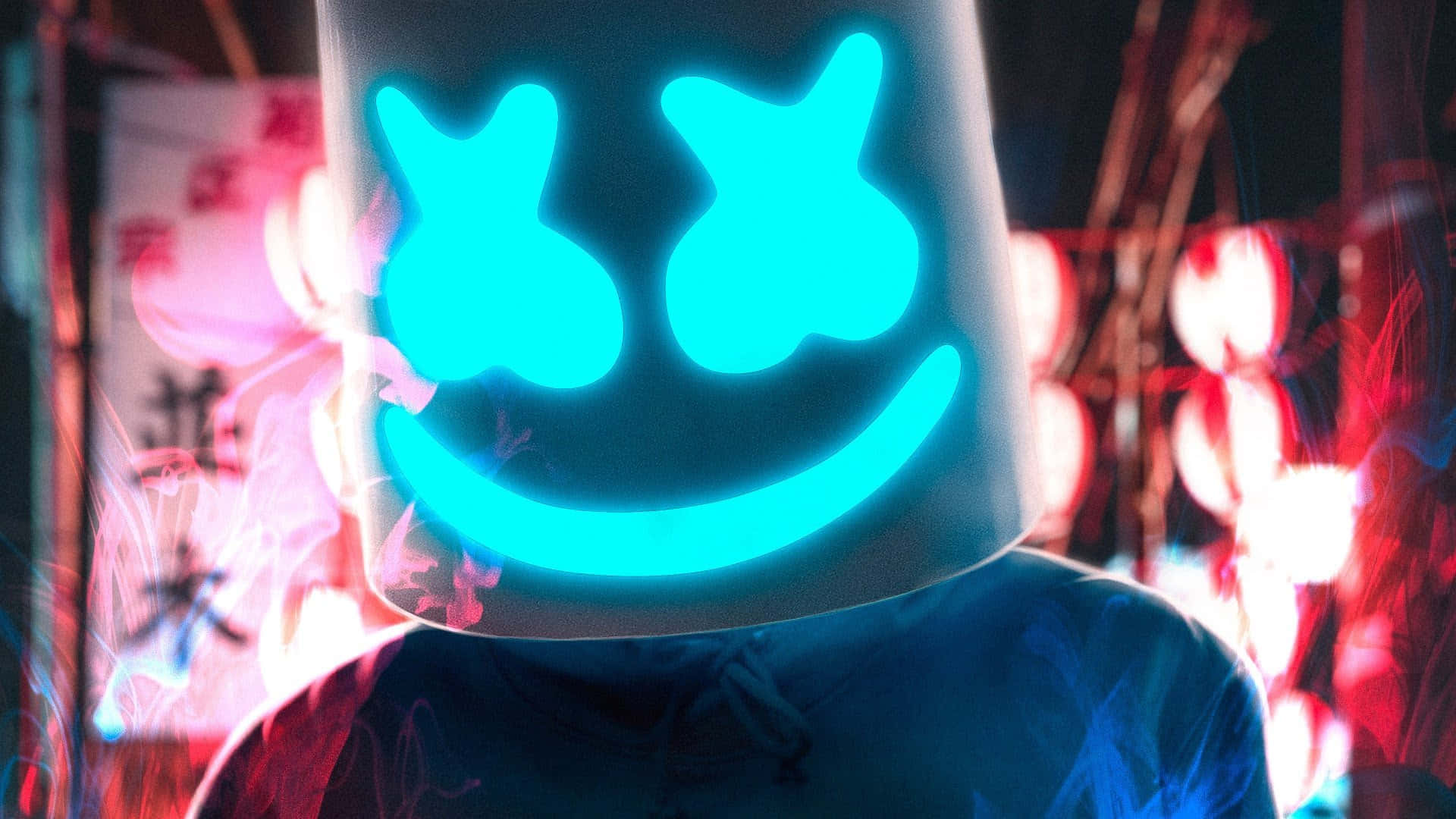 Marshmello 桌布 壁紙 — 一個戴著發光藍色笑臉頭盔的人站在煙霧彌漫、霓虹燈閃爍的都市夜景中，周圍有紅色和粉紅色的燈光。