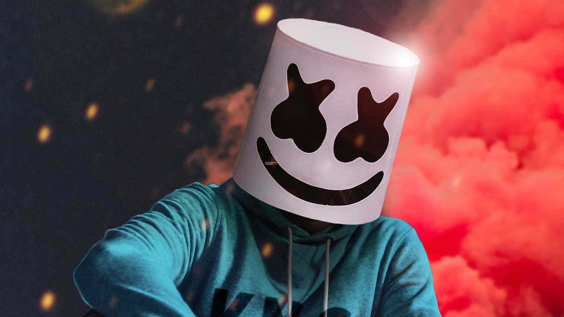 Marshmello 桌布 壁紙 — 一個戴著白色棉花糖頭盔、面帶微笑的人，站在戲劇性的紅色煙霧和黑暗天空前，周圍有發光的粒子。