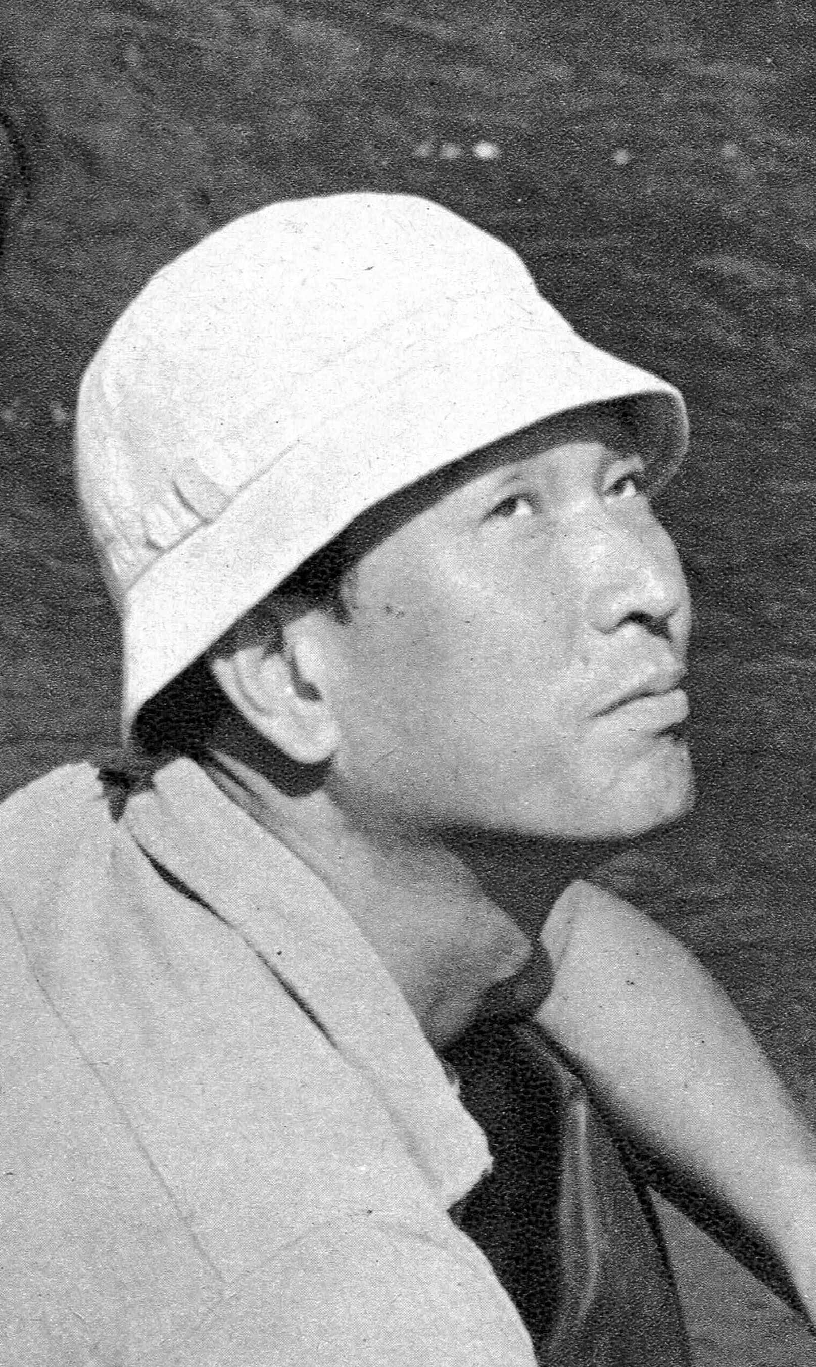 Akira Kurosawa 桌布 壁紙 — 一個戴著白色漁夫帽的男人，在深色紋理背景前，以顆粒狀的黑白肖像照若有所思地向上凝視。
