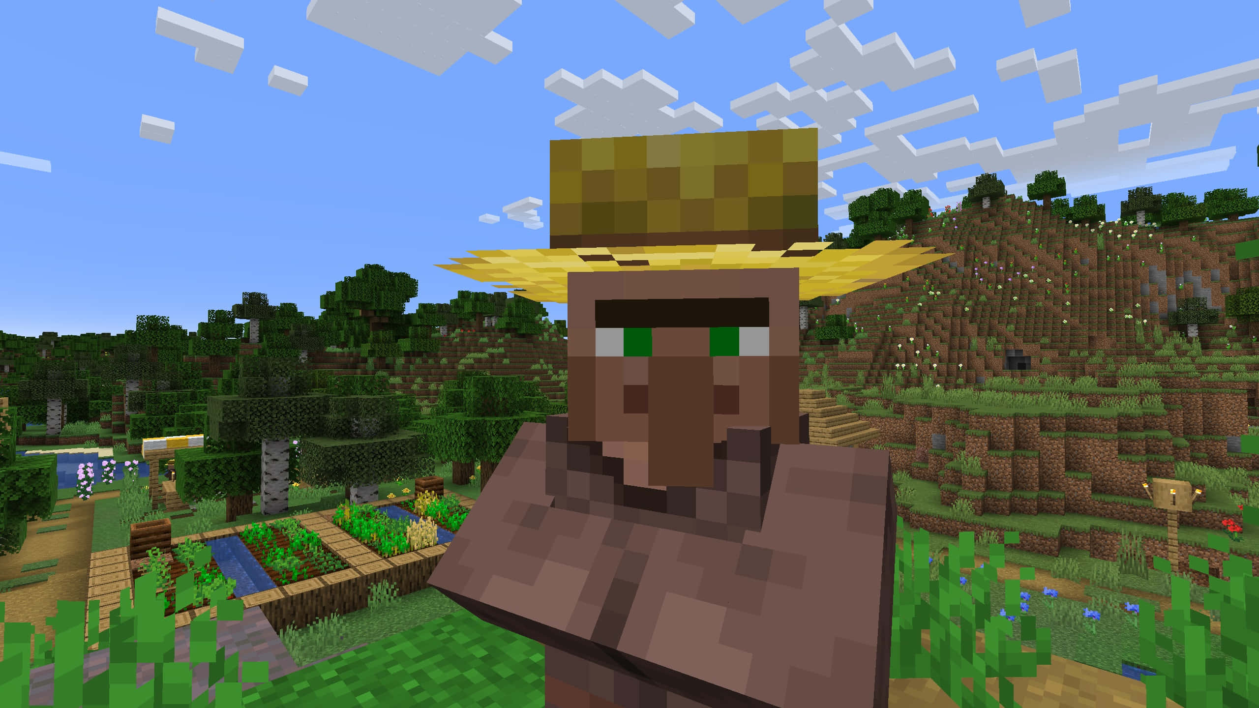Minecraft Villager 桌布 壁紙 — 一個戴著草帽的像素化Minecraft村民站在一個綠意盎然的村莊中，背景是晴朗的藍天和 fluffy 雲朵。