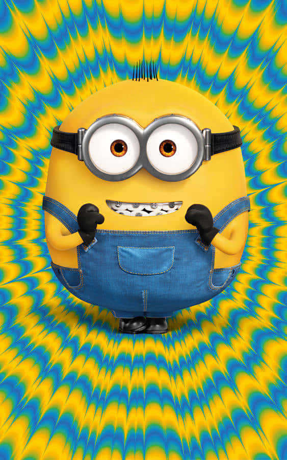 迷你兵團 桌布 壁紙 — 一個戴著護目鏡和牛仔布工裝褲的黃色Minion站在迷幻的藍色和黃色漩渦背景前。