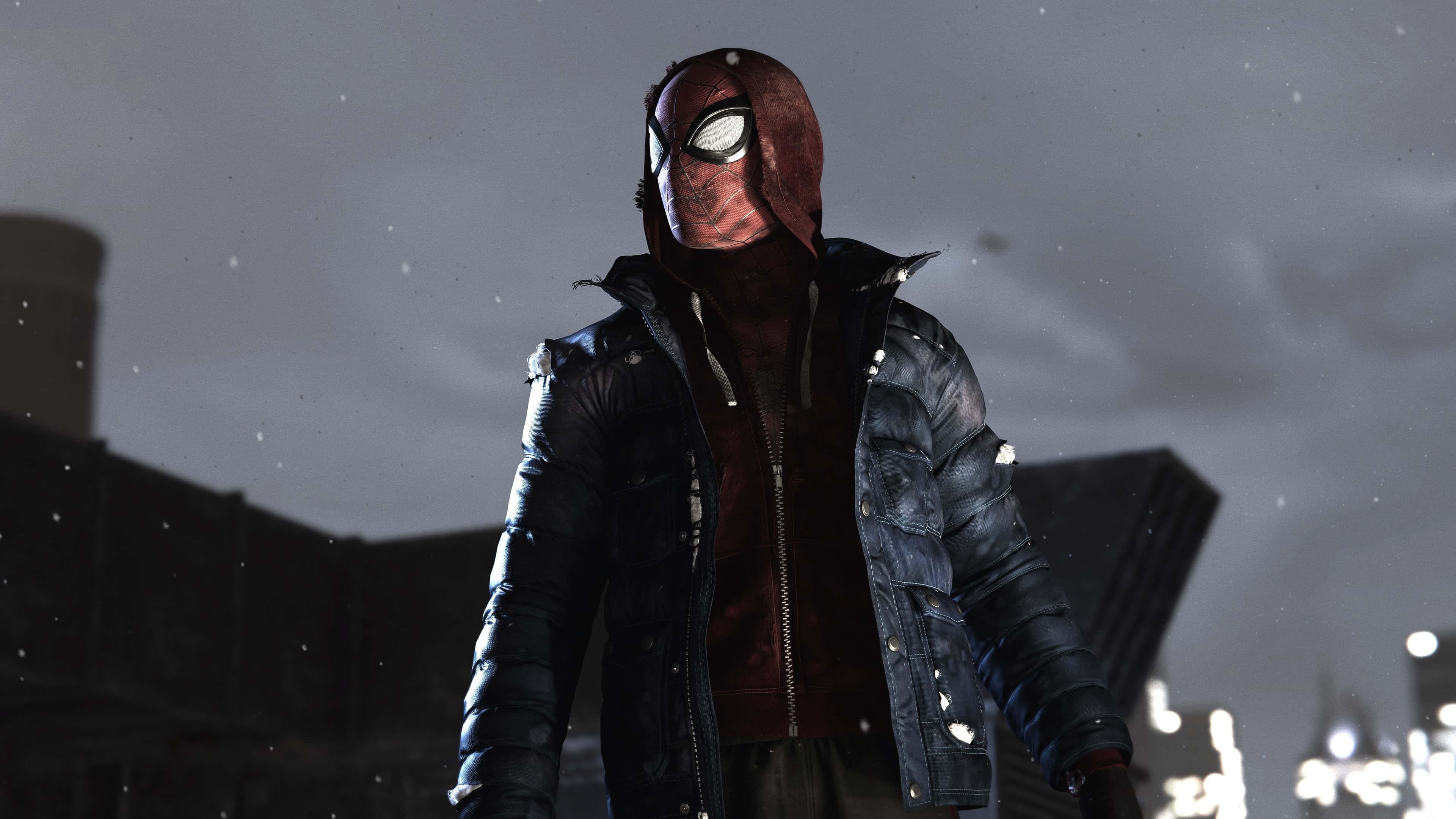 Superhero Video Games 桌布 壁紙 — 一個戴著面具的超級英雄穿著深色外套，站在雪夜的城市中，背景是閃爍的城市燈光。