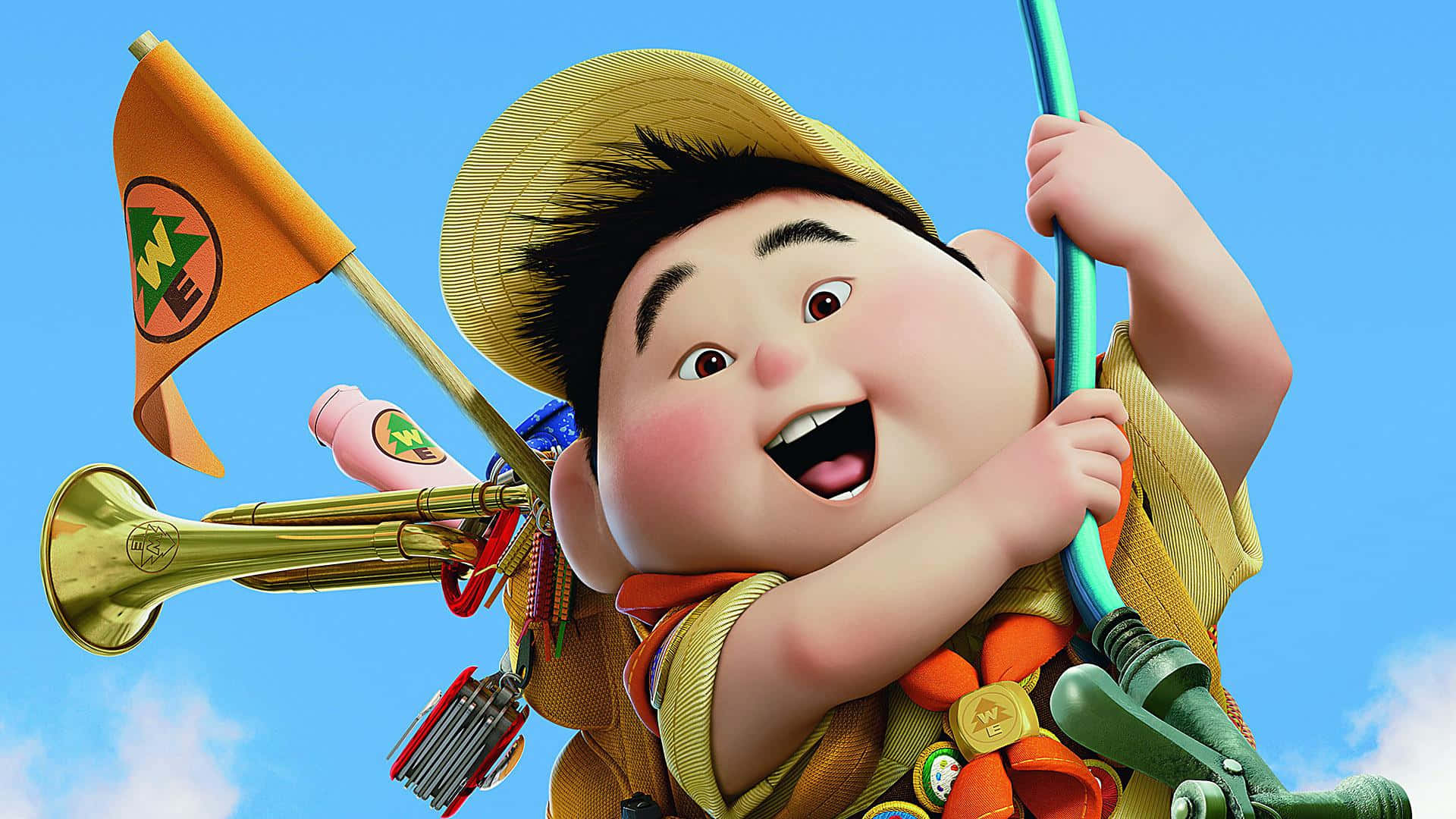 Disney 3d Movies 桌布 壁紙 — 一個戴著黃色帽子和穿著童軍制服的可愛動畫男孩，在明亮的藍天下微笑著拿著旗子和號角。