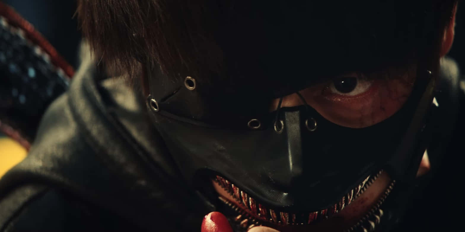 Tokyo Ghoul Movie 桌布 壁紙 — 一個戴著黑色皮革面具、帶有金屬孔眼和拉鍊嘴巴、露出尖牙的蒙面人物的特寫。