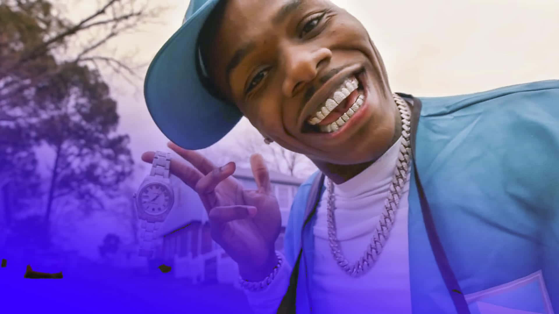 Dababy 桌布 壁紙 — 一個戴藍色帽子和穿藍色外套的微笑男子，在紫色戶外背景下舉起手錶並做出和平手勢。