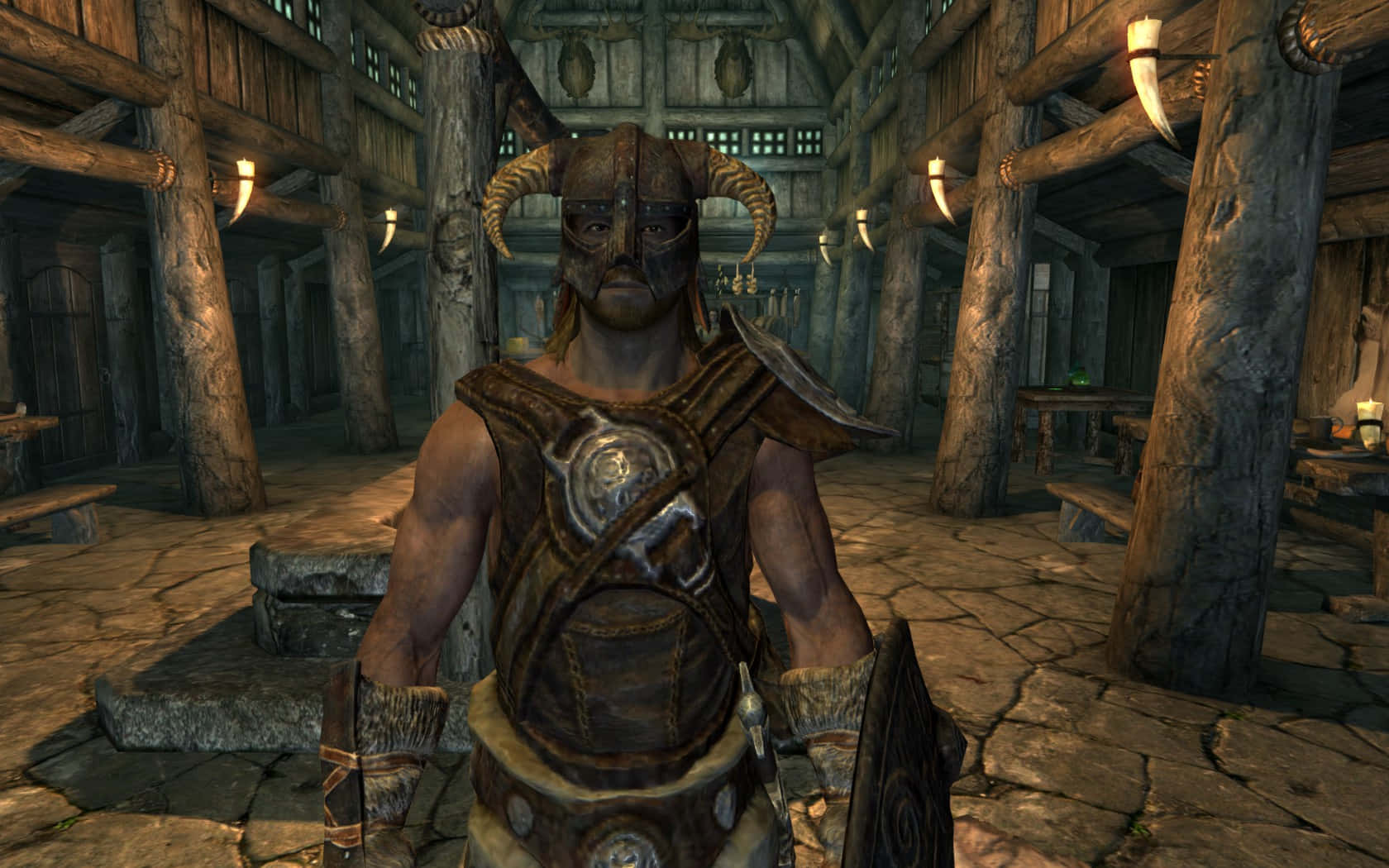 dovahkiin 桌布 壁紙 — 一個戴角面具、身穿皮甲的戰士站在一間有石地板和掛著動物牙齒的鄉村木製酒館中。