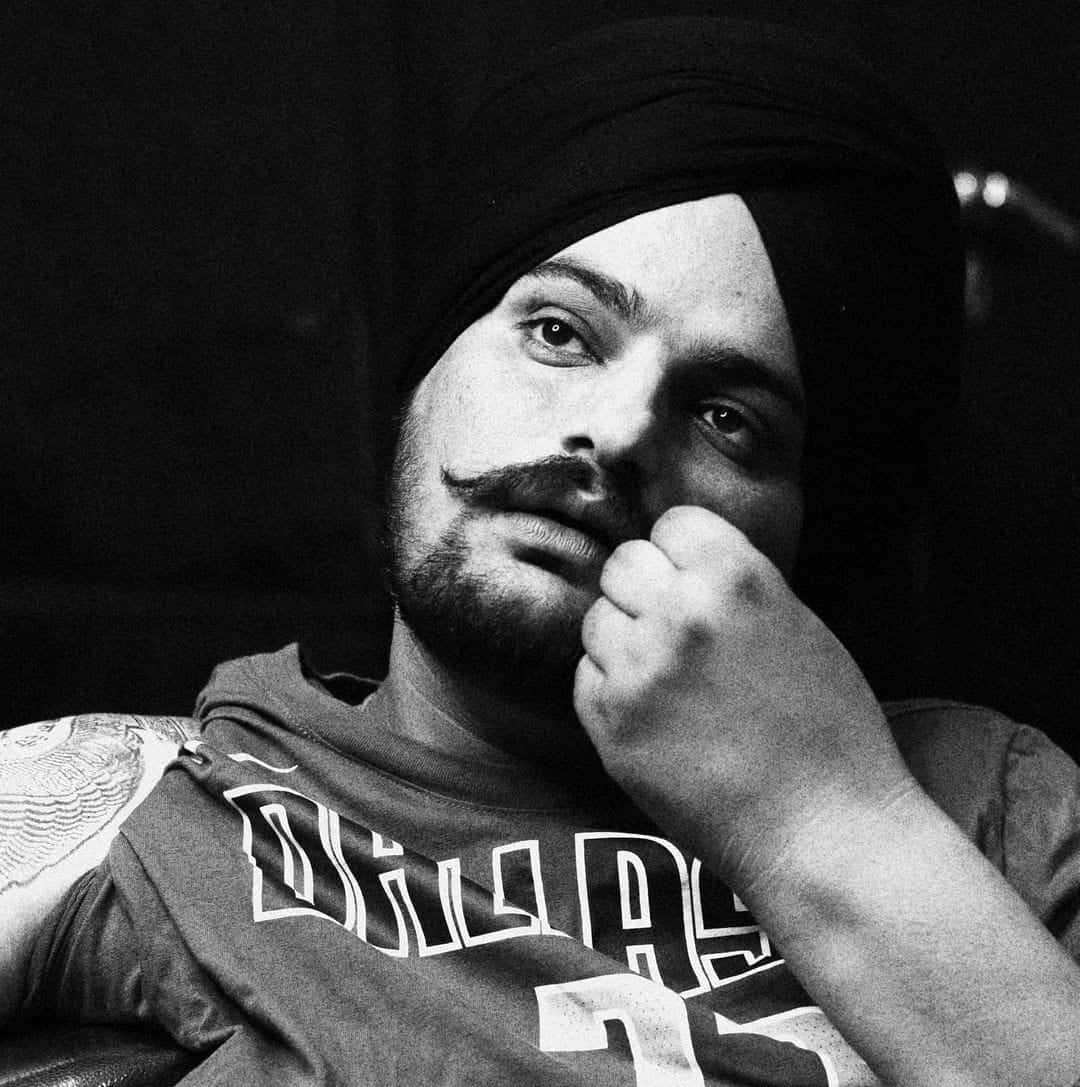 Sidhu Moose Wala 桌布 壁紙 — 一個戴頭巾、留鬍子的男人，拳頭托著下巴的黑白肖像。
