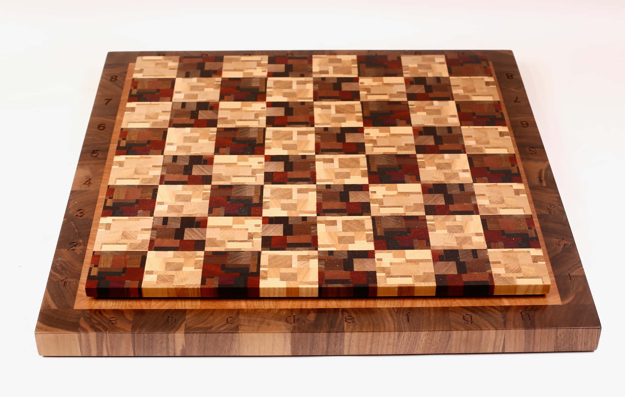 Chessboard 桌布 壁紙 — 一個手工製作的木製國際象棋棋盤，帶有複雜的馬賽克方格和編號邊緣，置於潔淨的白色背景上。