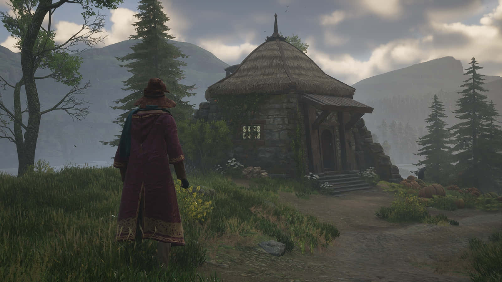 Hagrid's Hut 桌布 壁紙 — 一個披著斗篷的身影站在一間簡樸的石屋前，石屋有茅草屋頂，坐落於霧氣瀰漫的山林之中。