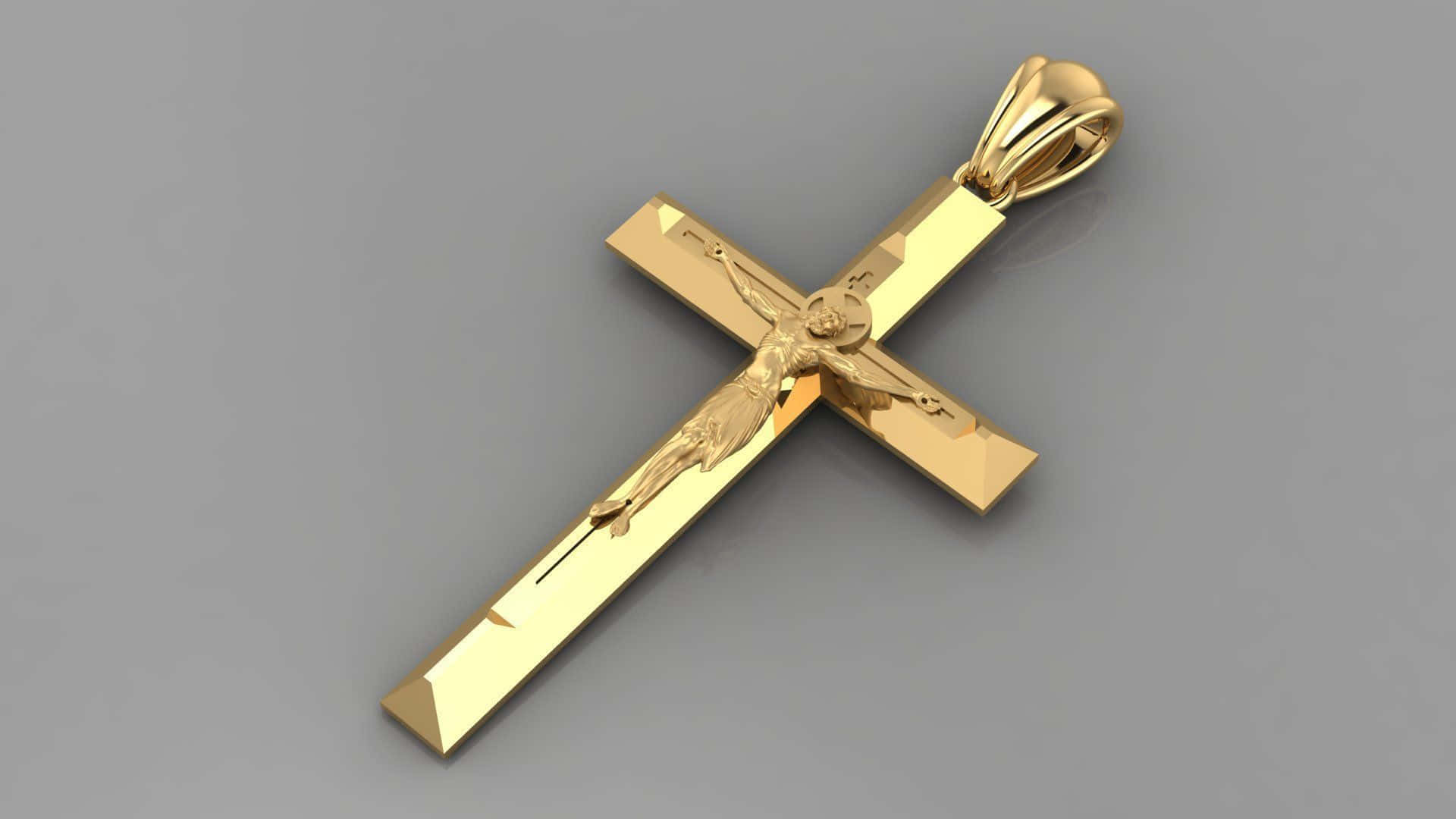 Cool Cross 桌布 壁紙 — 一個拋光金色十字架吊墜，帶有詳細的耶穌像，放置在中性灰色表面上。