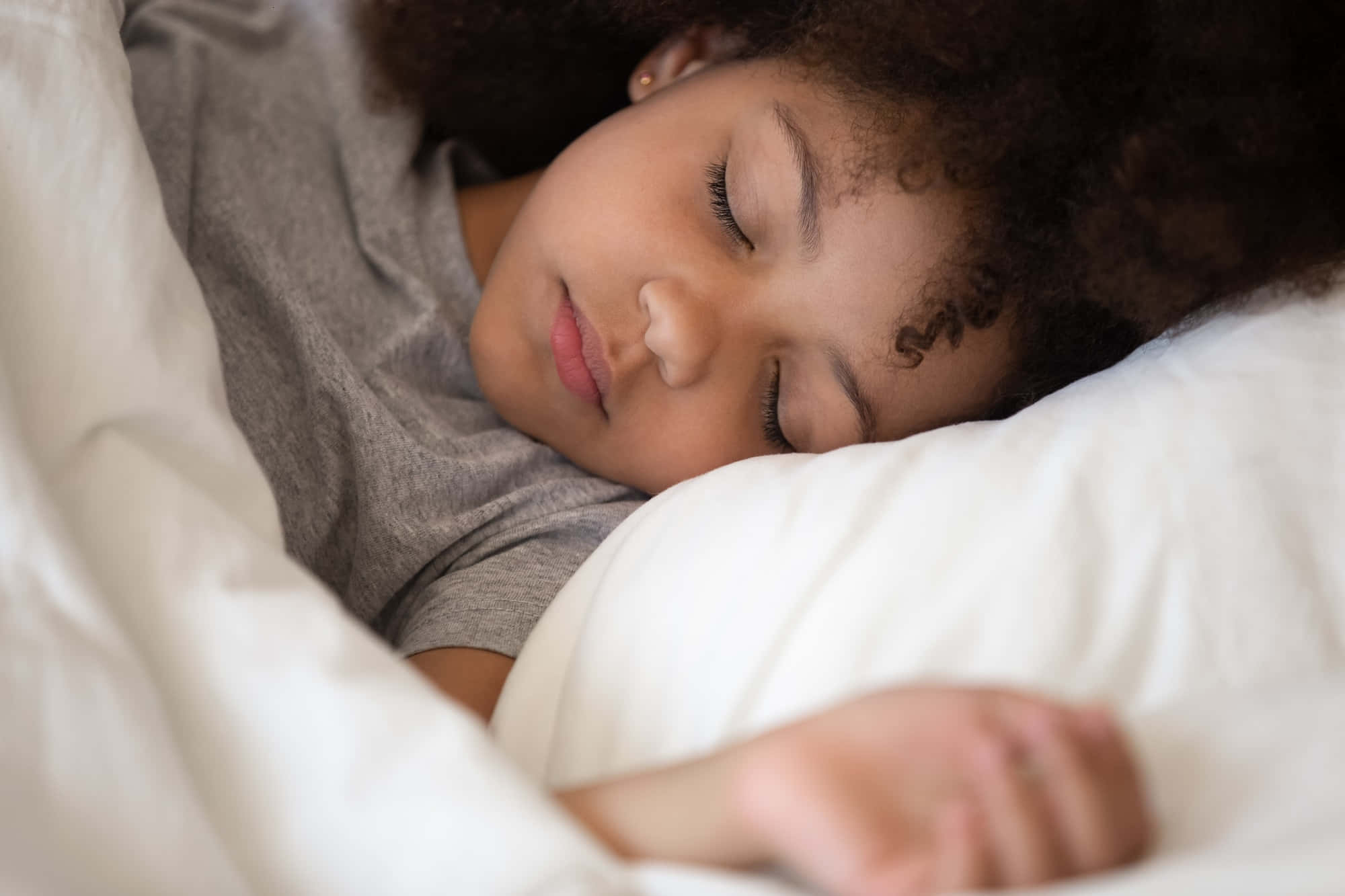 Sleep 桌布 壁紙 — 一個捲髮小女孩裹著柔軟的白色毛毯在床上安睡。