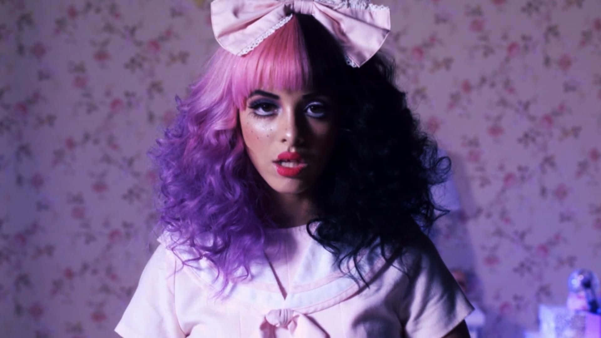 Melanie Martinez 桌布 壁紙 — 一個擁有粉紅和紫色頭髮、戴著大蝴蝶結的人，在紫色燈光下對著花卉牆紙凝視。