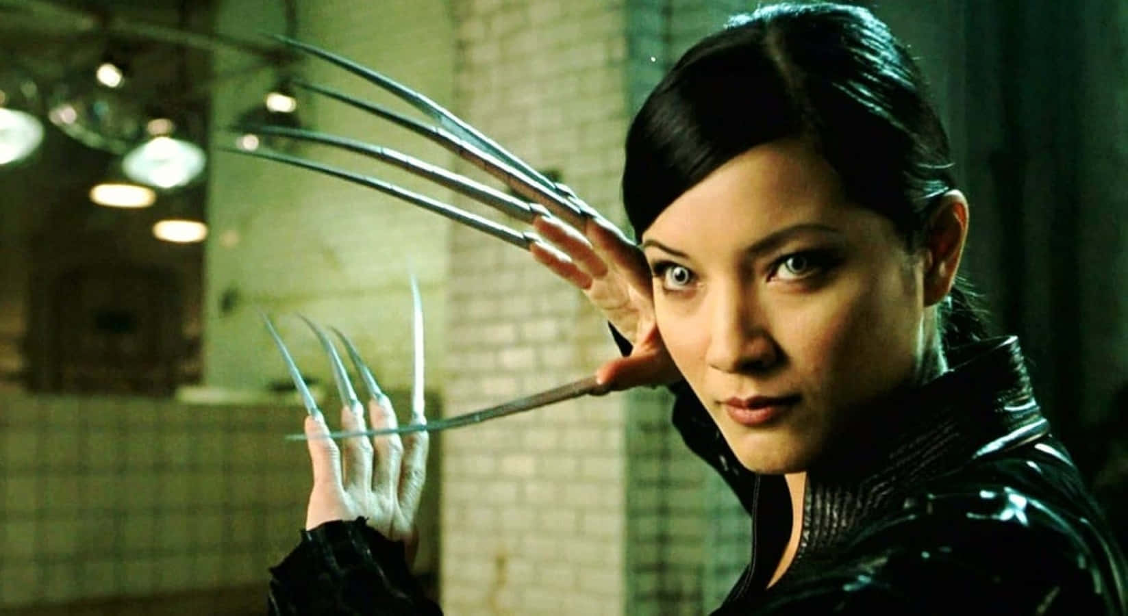 Lady Deathstrike 桌布 壁紙 — 一個擁有金屬爪的兇猛女人在昏暗的瓷磚房間中伸出雙手，眼睛鎖定著強烈的目光。