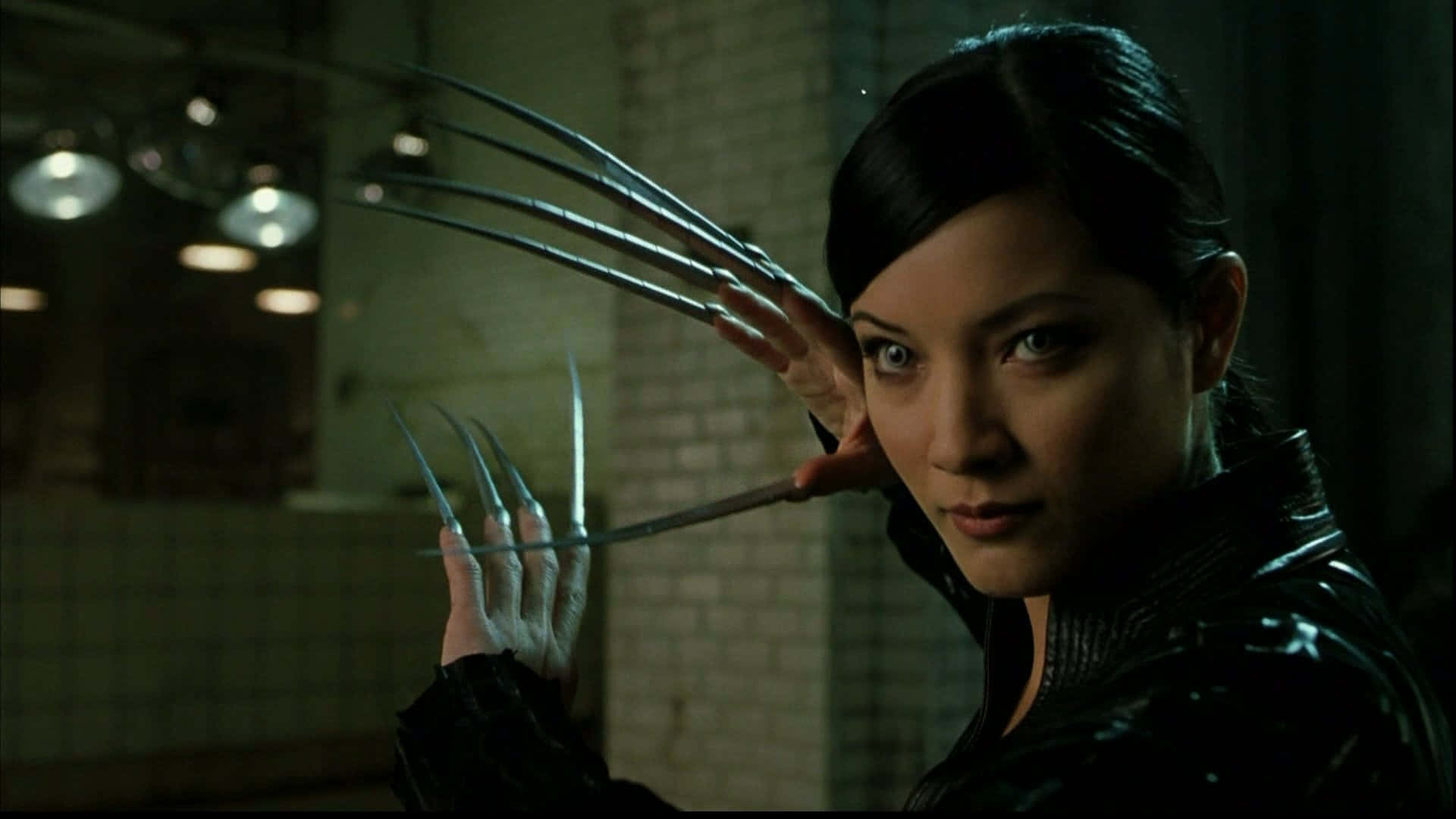 Lady Deathstrike 桌布 壁紙 — 一個擁有金屬爪的女人在一個光線昏暗的瓷磚房間裡，懸掛著燈飾，伸出雙手。