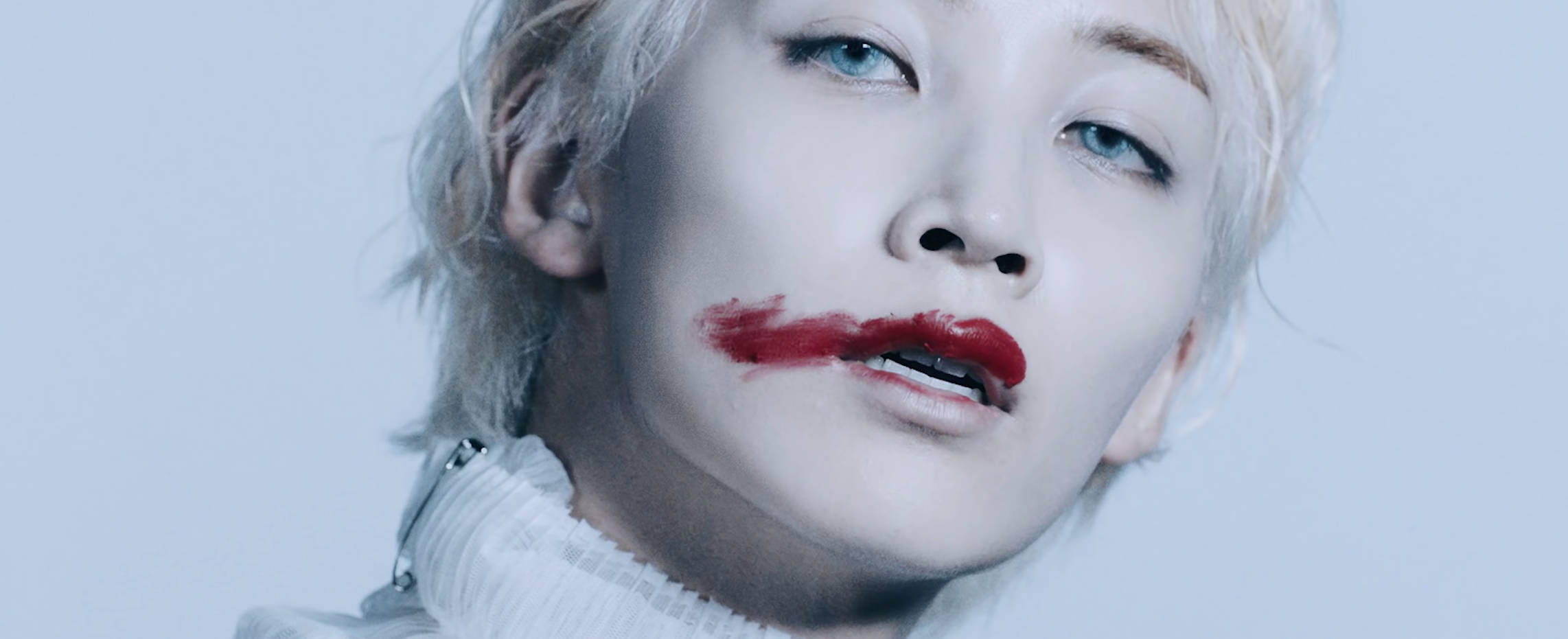 Yoon Jeonghan Fear 壁紙 — 一個擁有鉑金色頭髮和鮮豔紅唇的人，在淡藍色背景下強烈凝視。