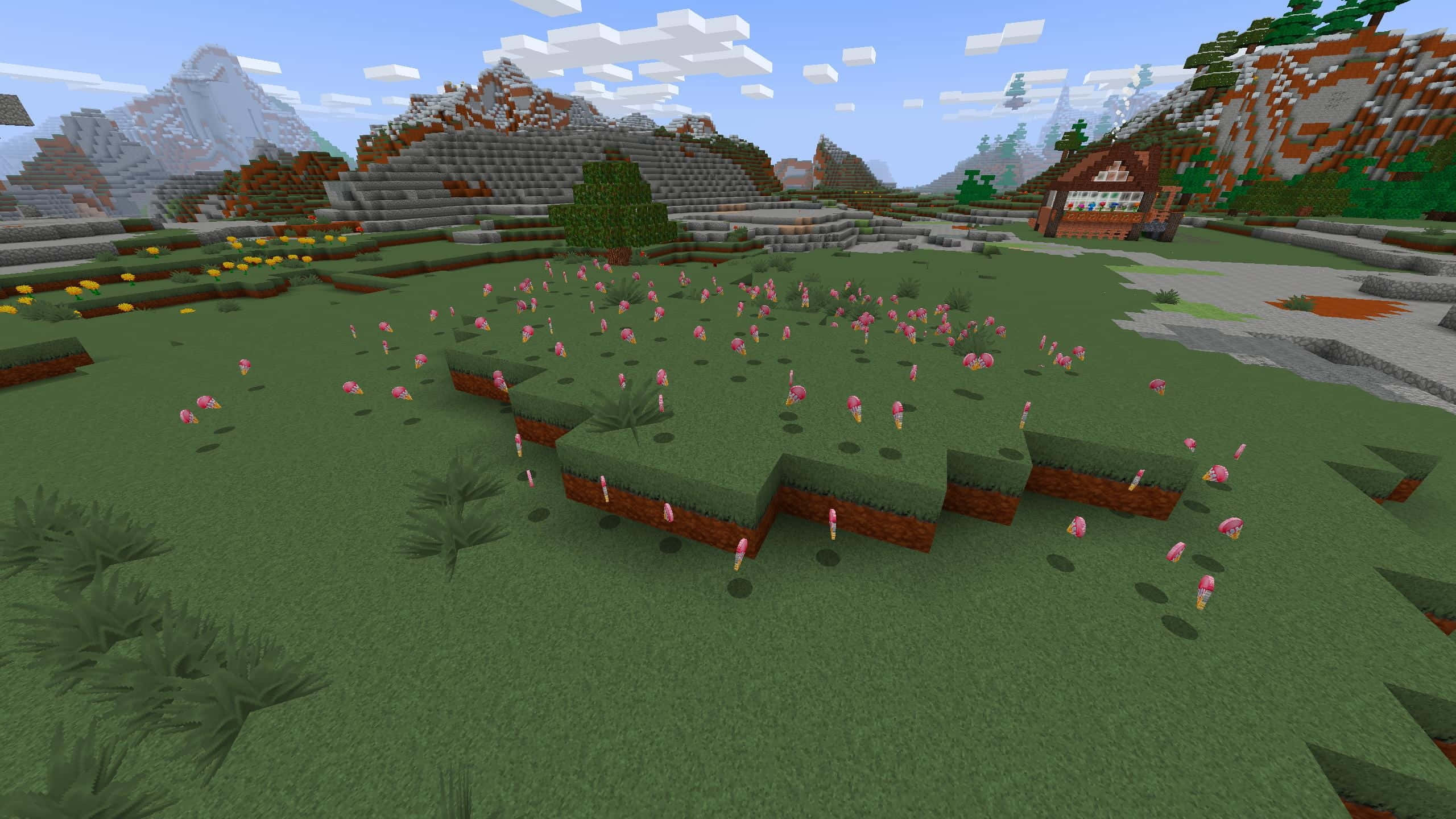 Minecraft Adventure 桌布 壁紙 — 一個方塊狀的Minecraft景觀，在藍天下，木屋和遠處山脈附近的草地上生長著粉紅色的花朵。