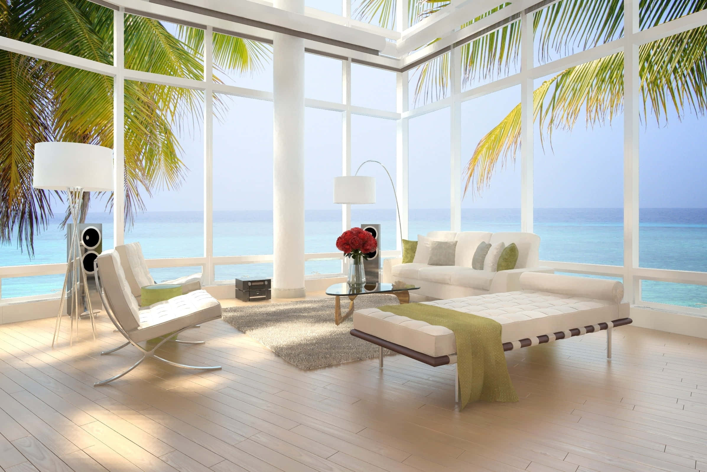 Beach Daybed 桌布 壁紙 — 一個明亮現代的客廳，配有白色家具，透過棕櫚樹環繞的落地窗俯瞰著碧綠色的海洋。