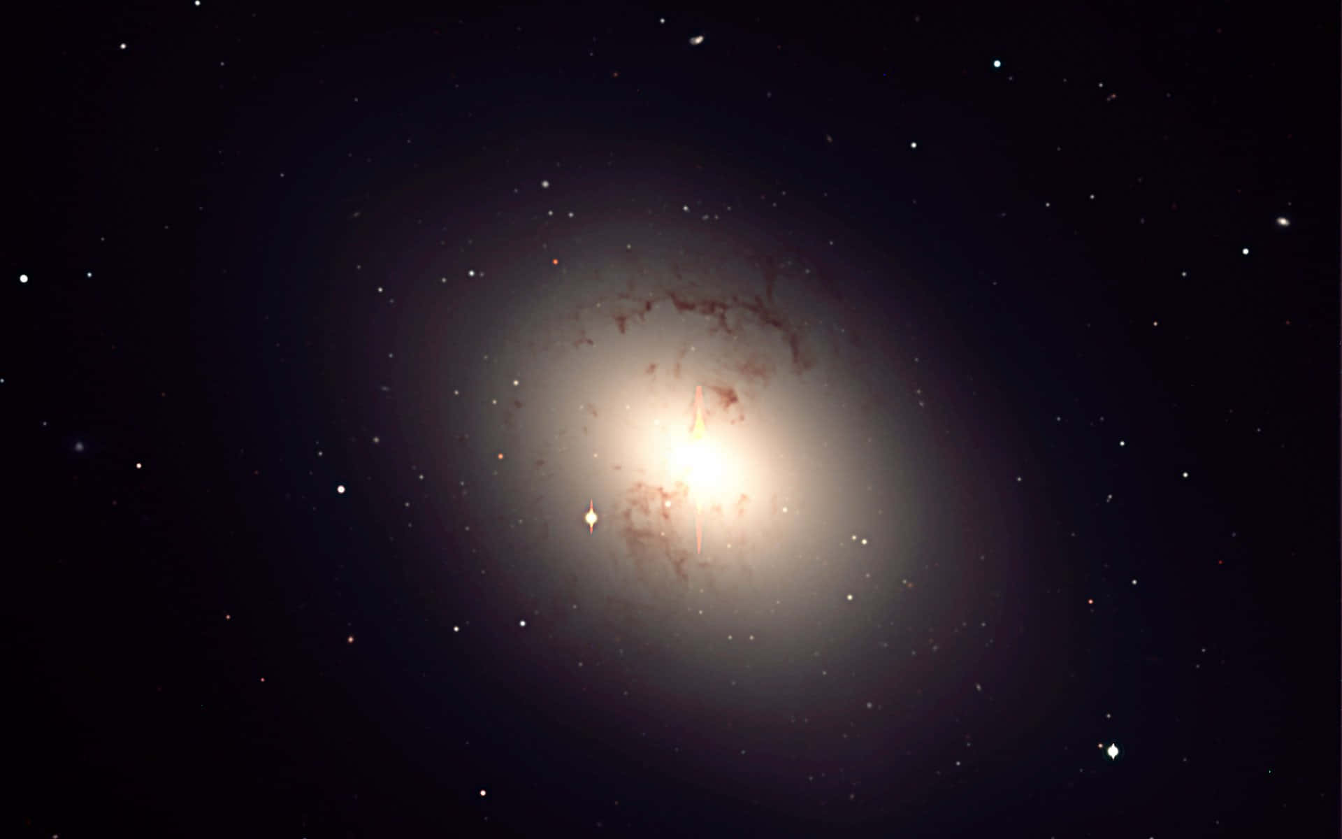 Elliptical Galaxy 桌布 壁紙 — 一個明亮的螺旋星系在佈滿星點的宇宙虛空中散發出溫暖的光芒。