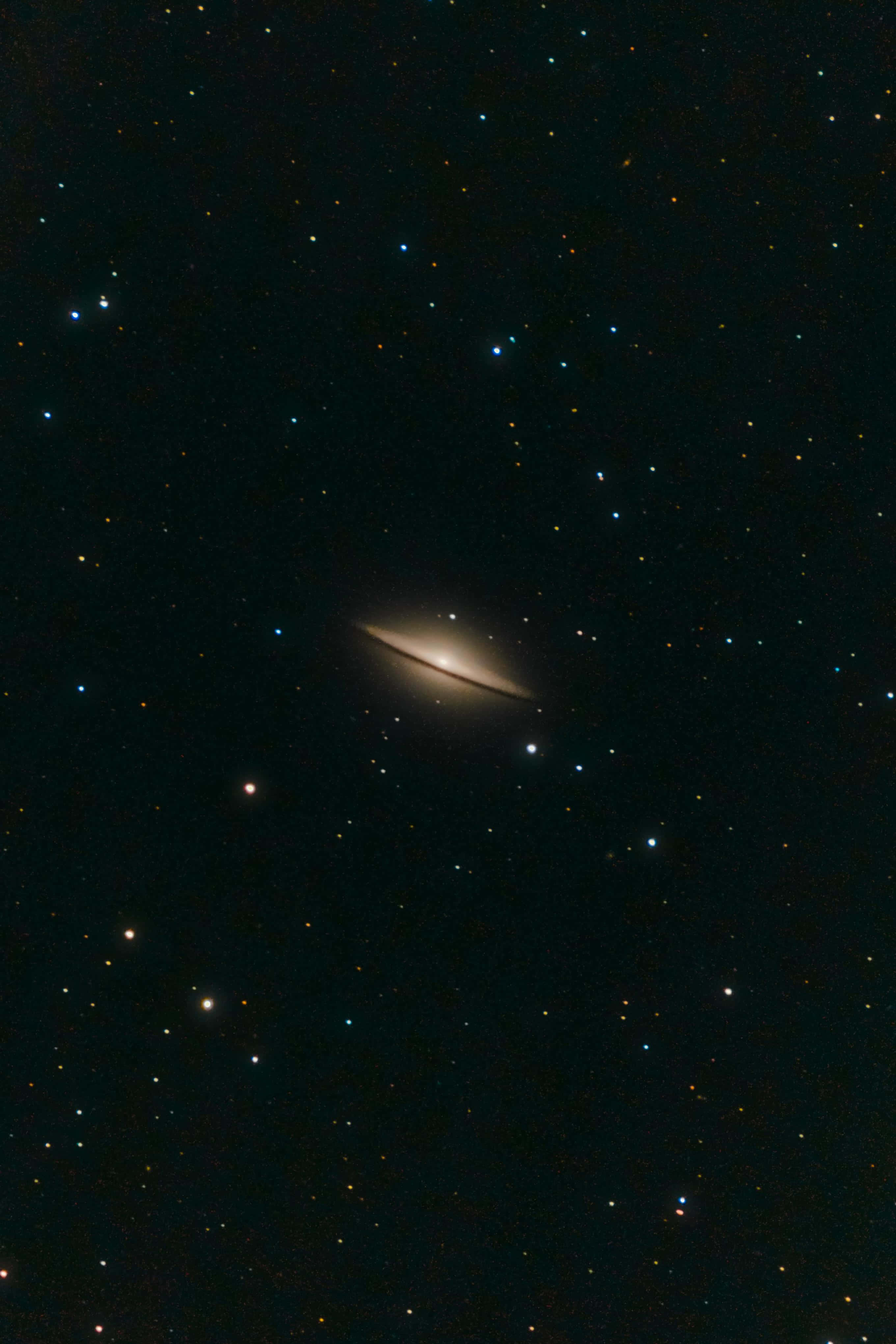 Sombrero Galaxy 桌布 壁紙 — 一個明亮的螺旋星系在深邃太空中無數遙遠恆星的背景下柔和地發光。