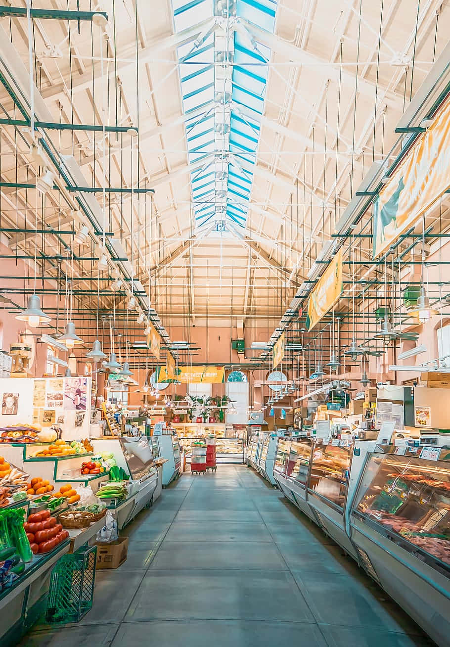 Grocery Store 桌布 壁紙 — 一個明亮通風的室內市場，擁有高玻璃天花板和成排的新鮮農產品和肉類櫃檯。
