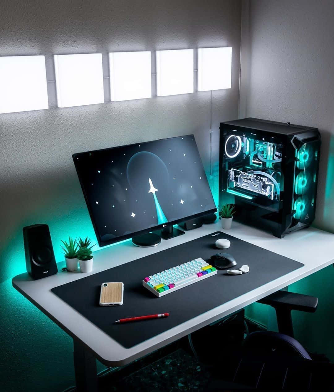 Gaming Accessories 桌布 壁紙 — 一個時尚的遊戲設置，配備發光RGB鍵盤、透明PC機箱和顯示器，在藍綠色環境光下顯示宇宙場景。