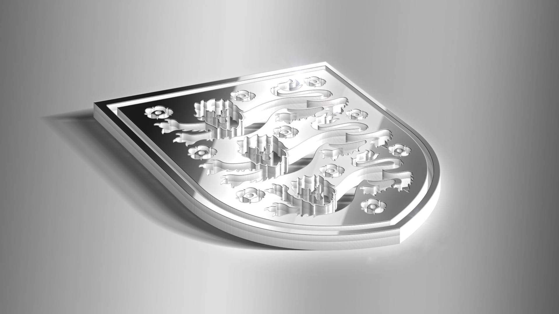 金屬動態圖 桌布 壁紙 — 一個時尚的銀色 3D 紋章盾牌，帶有浮雕獅子和花卉圖案，放置在漸變灰色表面上。
