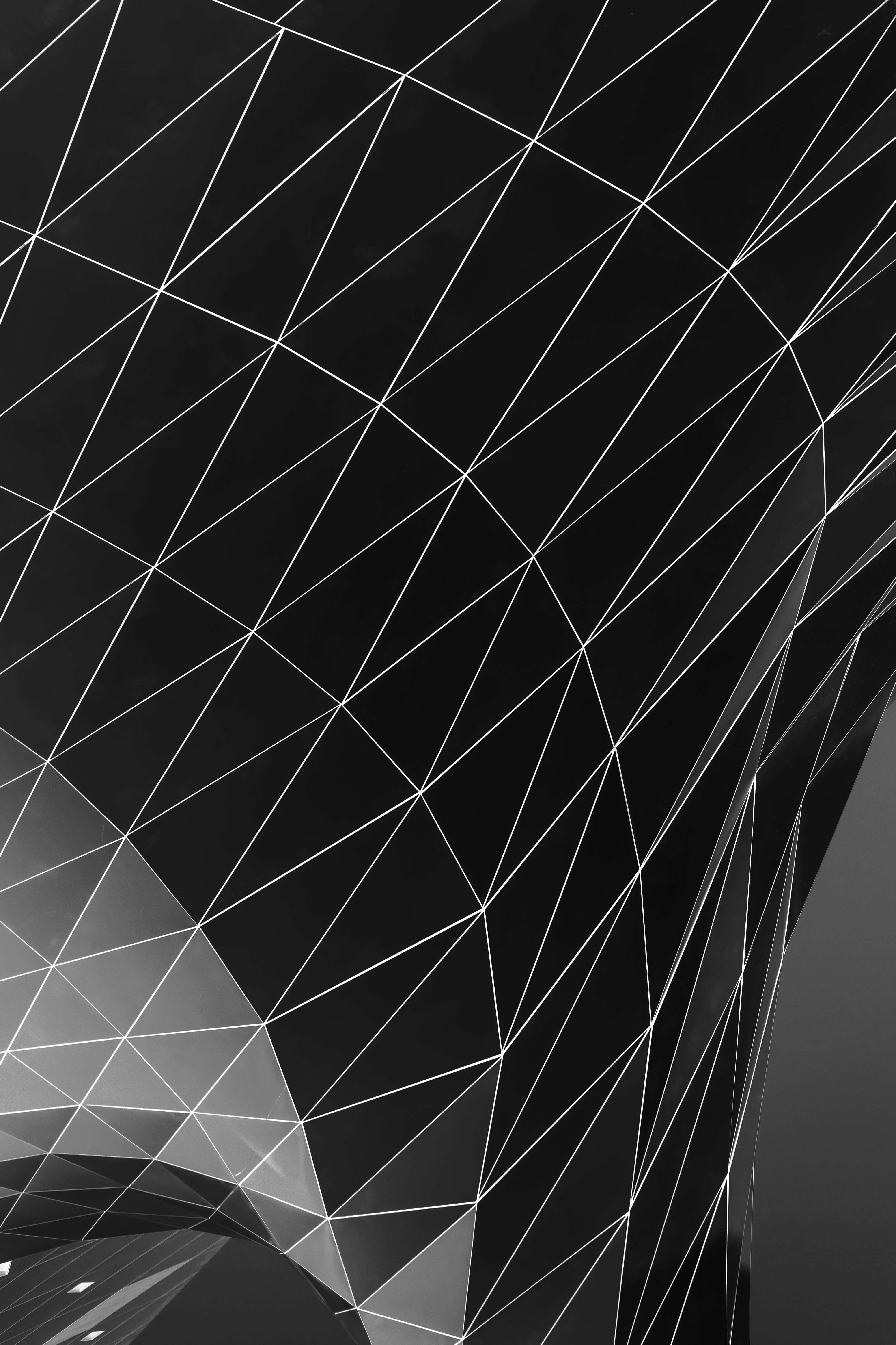 Black And White Geometric 桌布 壁紙 — 一個時尚的黑白抽象圖案，由交叉線條形成動態的三角形切面，帶有微妙的漸變高光。