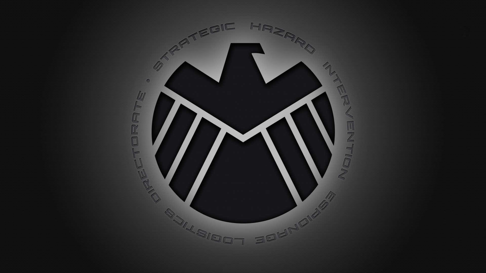 shield 桌布 壁紙 — 一個時尚的黑色和銀色SHIELD標誌，居中於帶有微妙照明的深色漸變背景上。