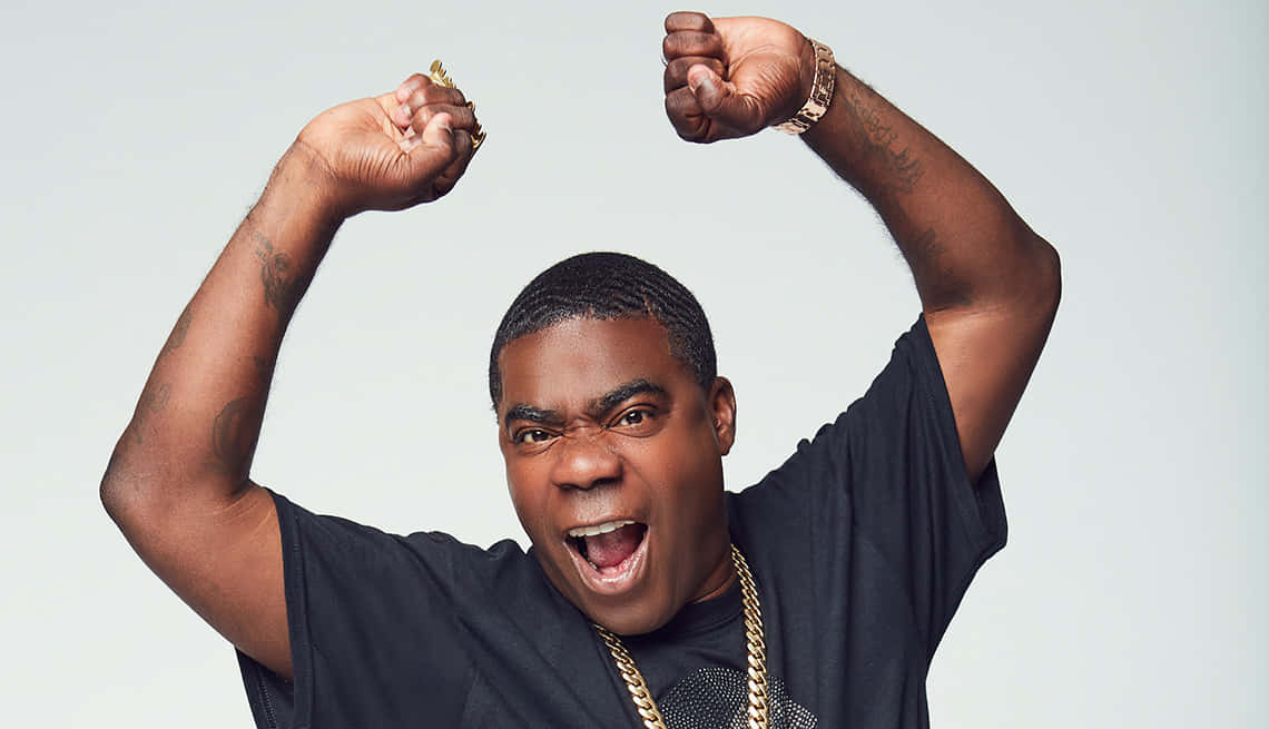 Tracy Morgan 桌布 壁紙 — 一個有紋身和戴金鏈的男人在純白色背景前高舉雙拳，發出勝利的呼喊。