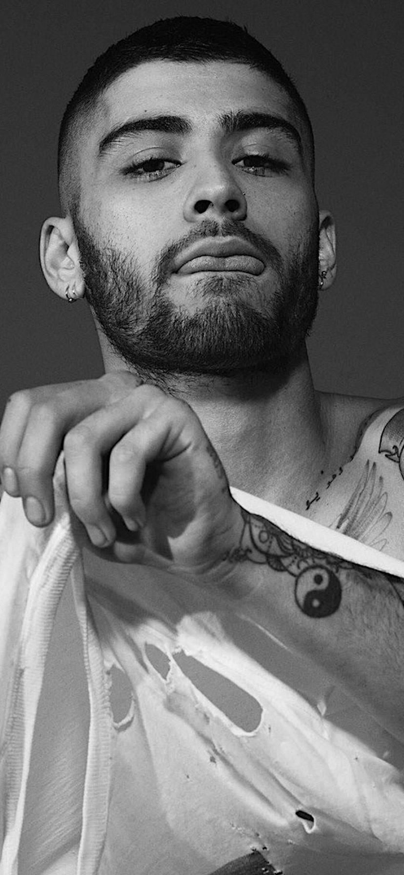 Celebrity 桌布 壁紙 — 一個有紋身和鬍鬚的男人的黑白肖像，直視鏡頭，表情嚴肅。