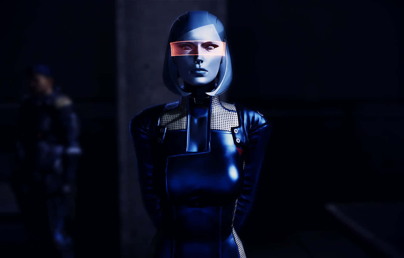 Mass Effect Edi 桌布 壁紙 — 一個未來主義的女性機械人，擁有發光的橙色眼睛，站在黑暗的工業環境中，她時尚的藍色套裝反射著冷光。