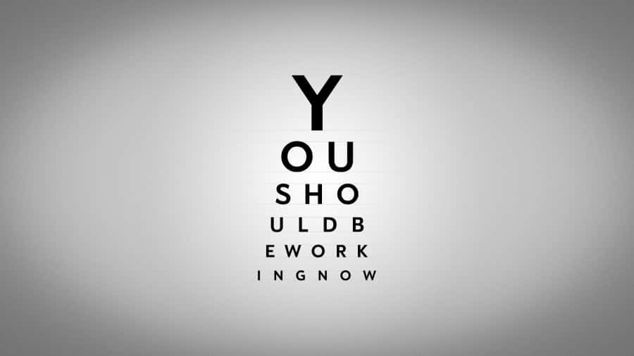 Black And White Typography 桌布 壁紙 — 一個極簡的視力表，在柔和的灰色漸變背景上，用粗體黑色字母創意地拼出「你現在應該工作」。