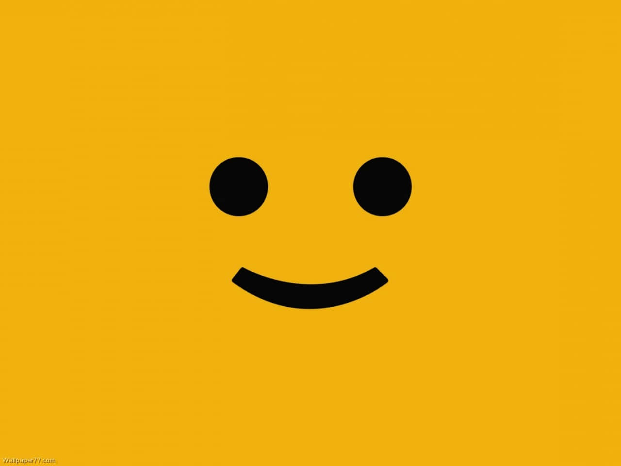 Smiley 桌布 壁紙 — 一個極簡的黑色笑臉，有兩個點作為眼睛和一個彎曲的嘴巴，居中在純黃色背景上。