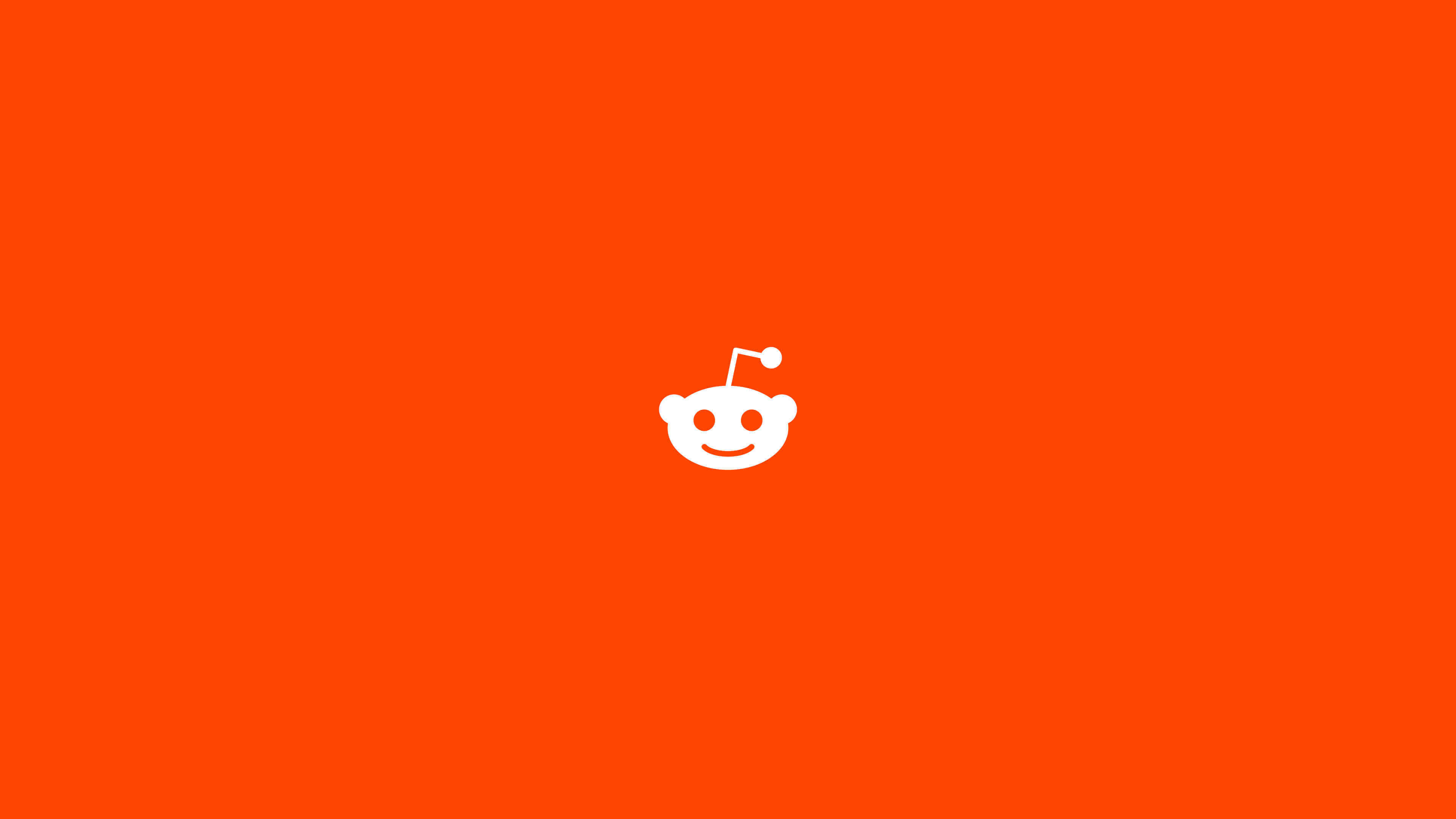 reddit 桌布 壁紙 — 一個極簡風格的白色外星人吉祥物，居中在純橙色背景上。