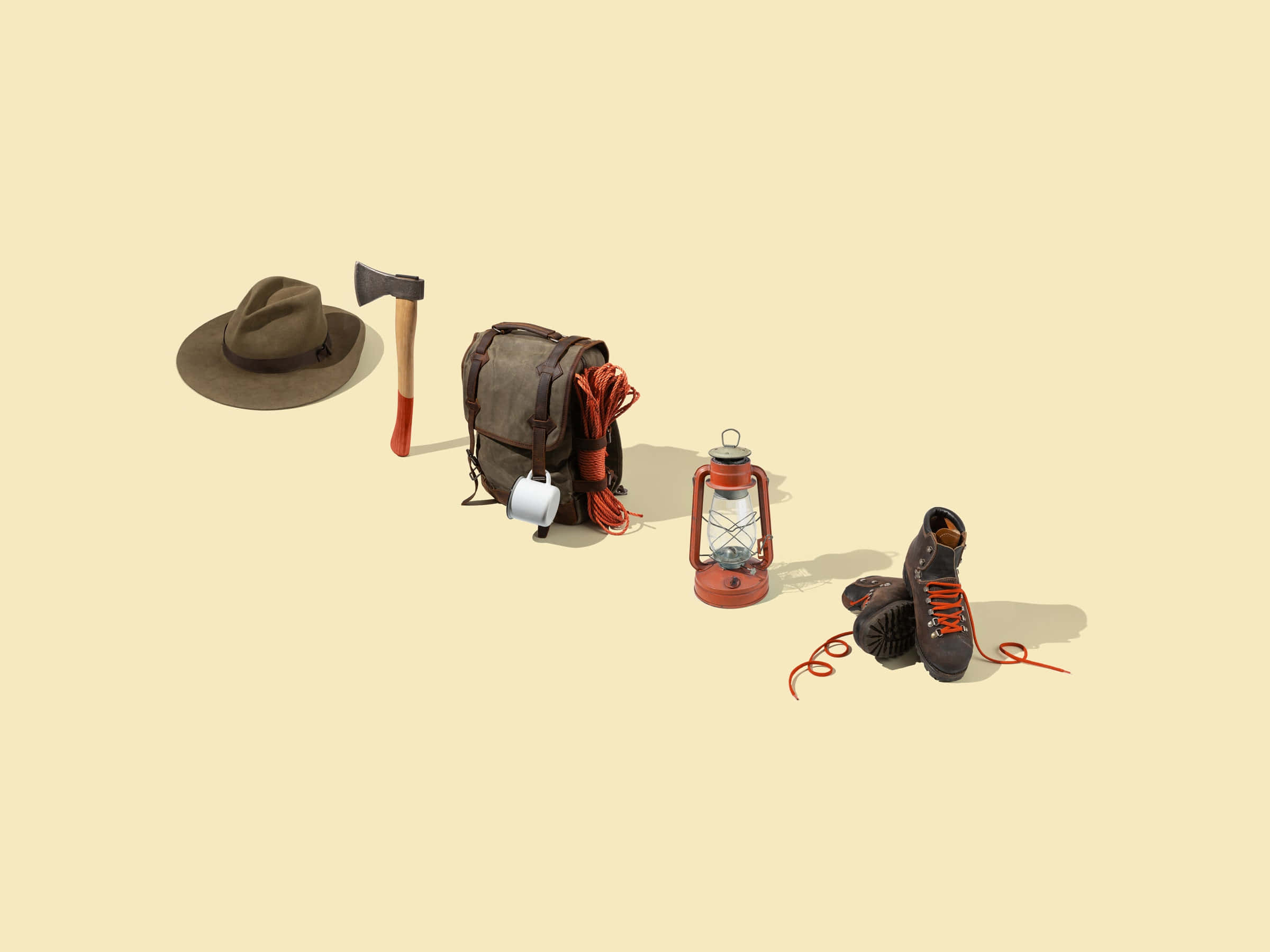 Hiking 桌布 壁紙 — 一個極簡風格的遠足裝備擺設，包括帽子、斧頭、背包、燈籠和靴子，放在米色背景上。