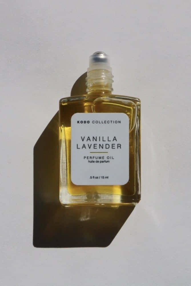 Rose Oil 桌布 壁紙 — 一個極簡風格的雲呢拿薰衣草香水油瓶，在明亮光線下於純白表面上投射出銳利的陰影。