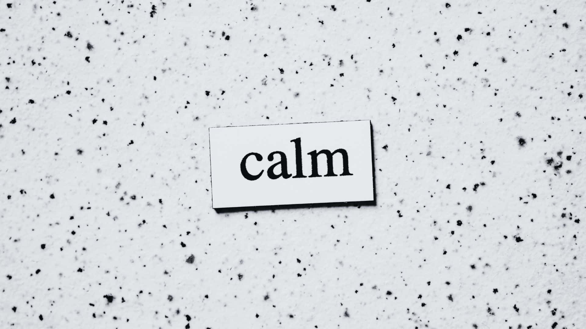 Black And White Word 桌布 壁紙 — 一個極簡黑白標牌，上面寫著 calm，放置在帶有斑點紋理的表面上。