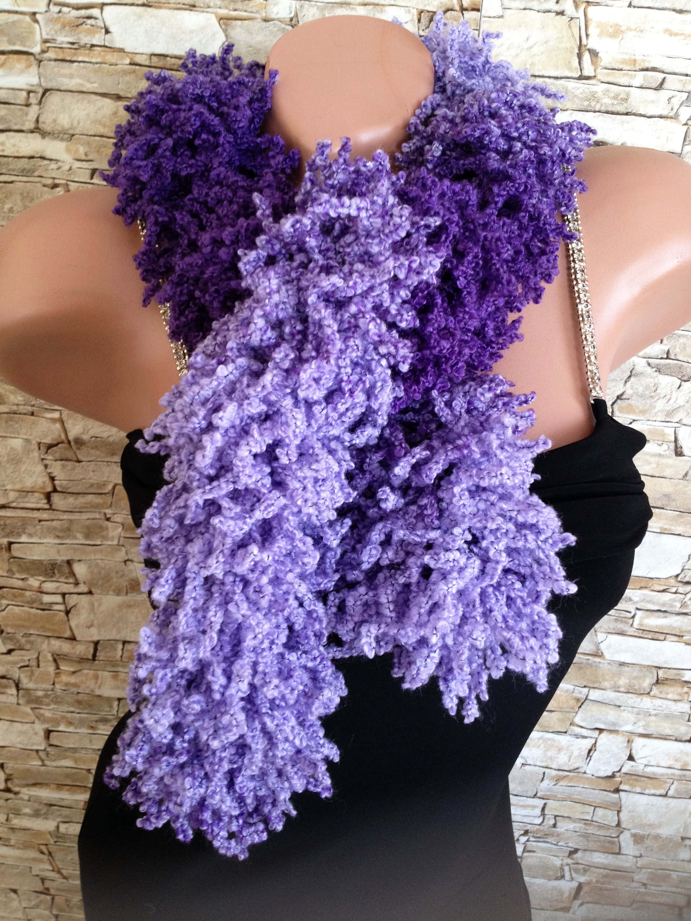 Purple Scarf 桌布 壁紙 — 一個模特兒人形穿著一件寬大的紫色流蘇圍巾，背景是石牆。