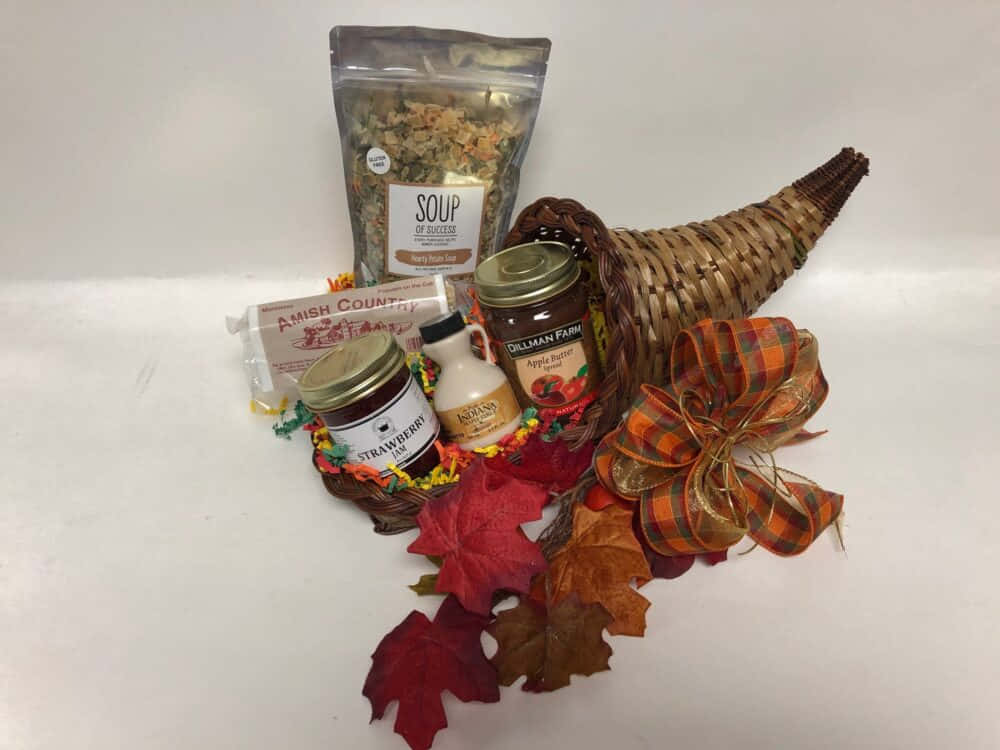Fall Cornucopia 桌布 壁紙 — 一個樸實的秋季豐收角，裝滿了秋季主題的食物和色彩繽紛的楓葉，背景是純白色。