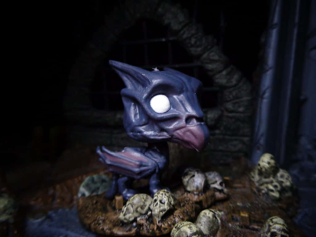 Thestral 桌布 壁紙 — 一個深紫色哥布林雕像，有一隻發光的白色眼睛，站在一個陰暗石壁龕中的頭骨底座上。